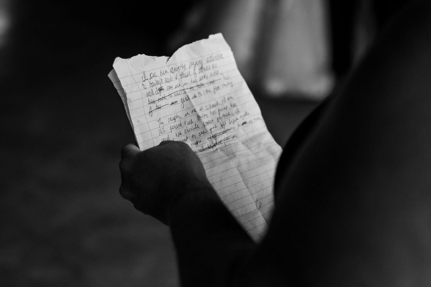 Black and white close-up of handwritten wedding vows on paper.