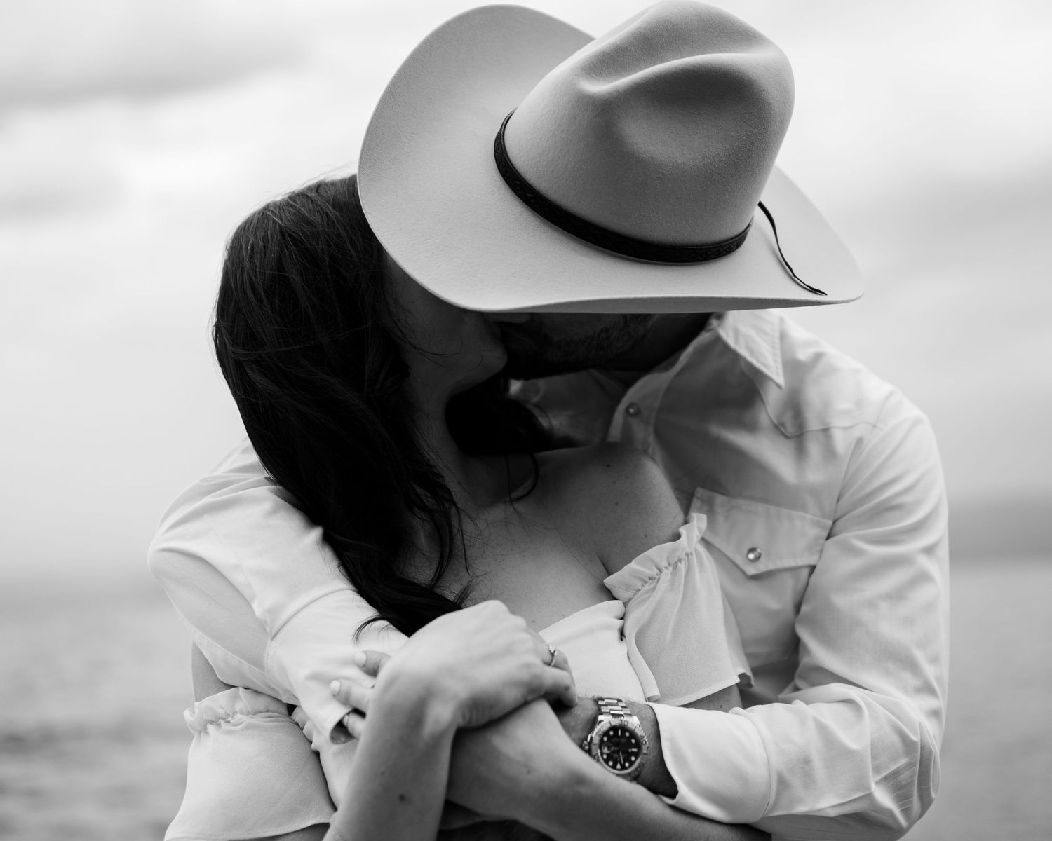 A romantic black and white photo sequence showing a couple in western attire sharing tender moments together.
