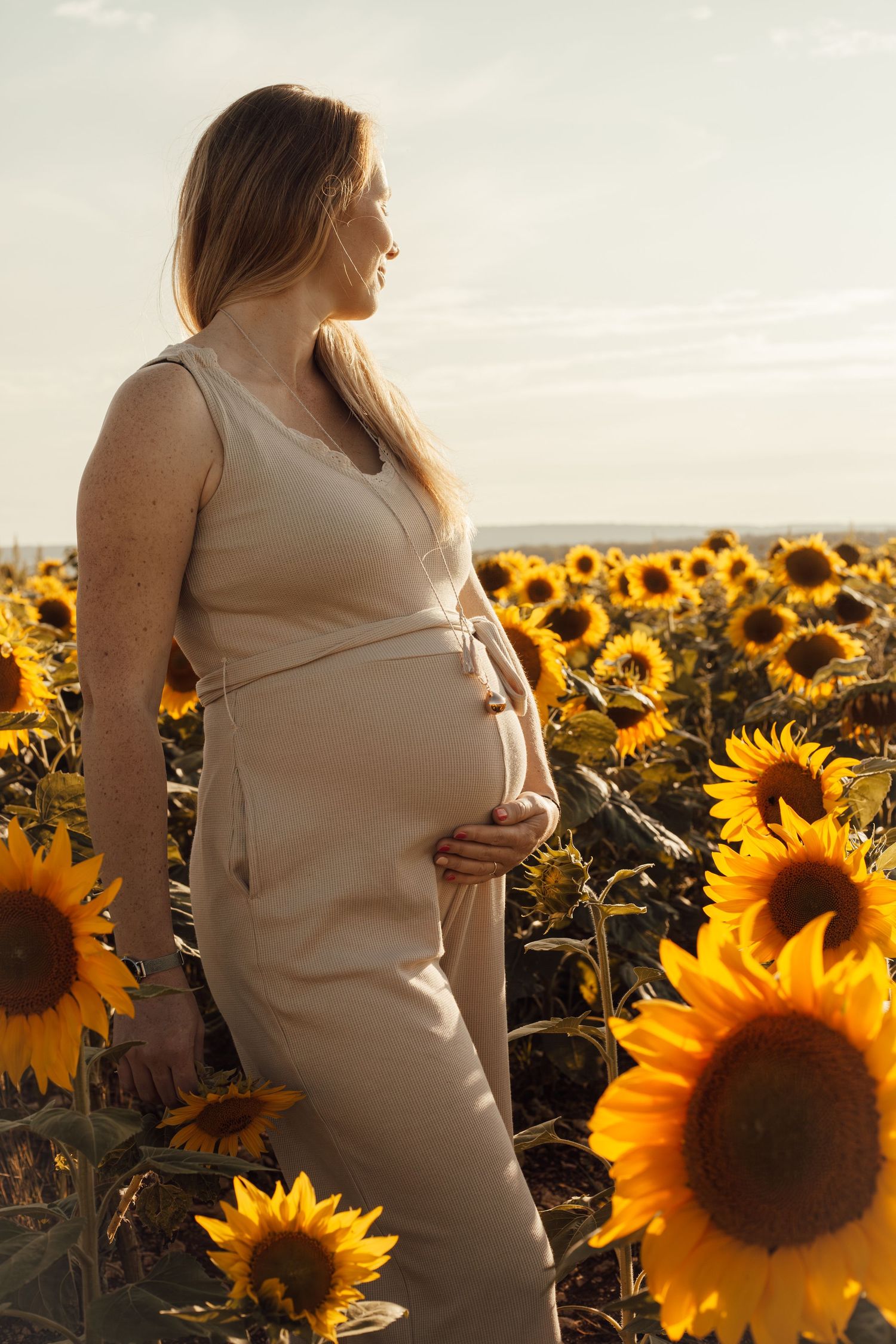 Séance photo grossesse en Lorraine – future maman dans un champ de tournesols