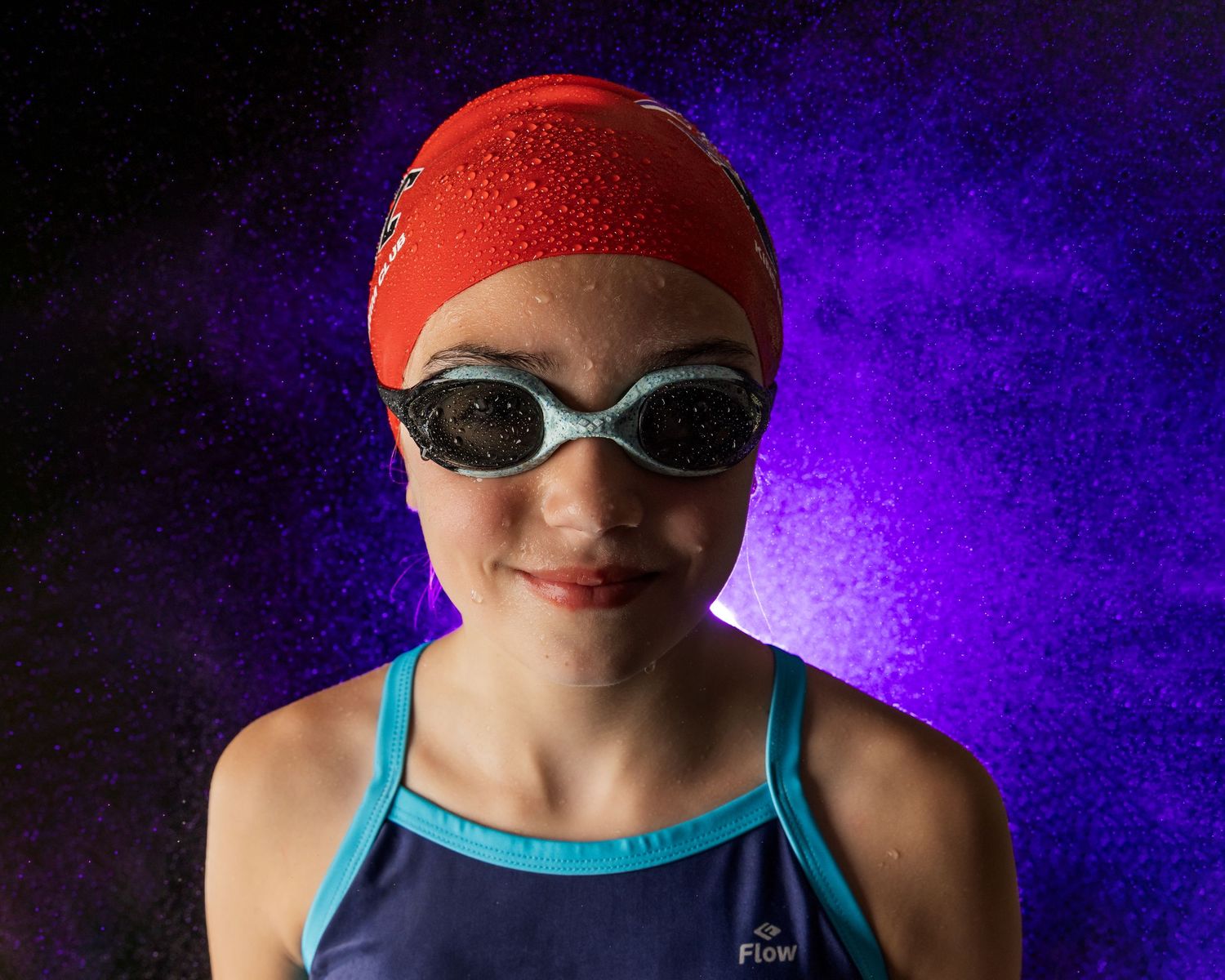 Swimmer in red cap and blue swimsuit photographed in multiple poses against purple background.