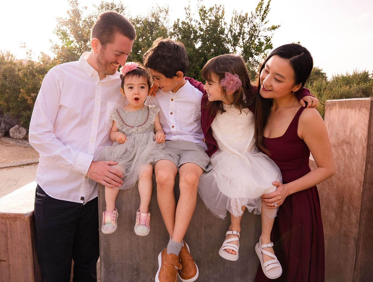 a fun portrait of a family of five all looking at the toddler in the family while the toddler makes a funny face