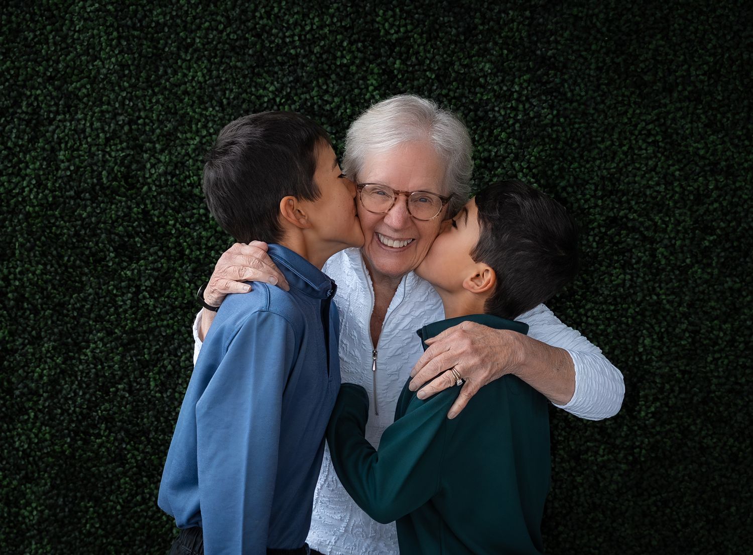 a loving photo of two boys kissing their grandma on each of her cheeks