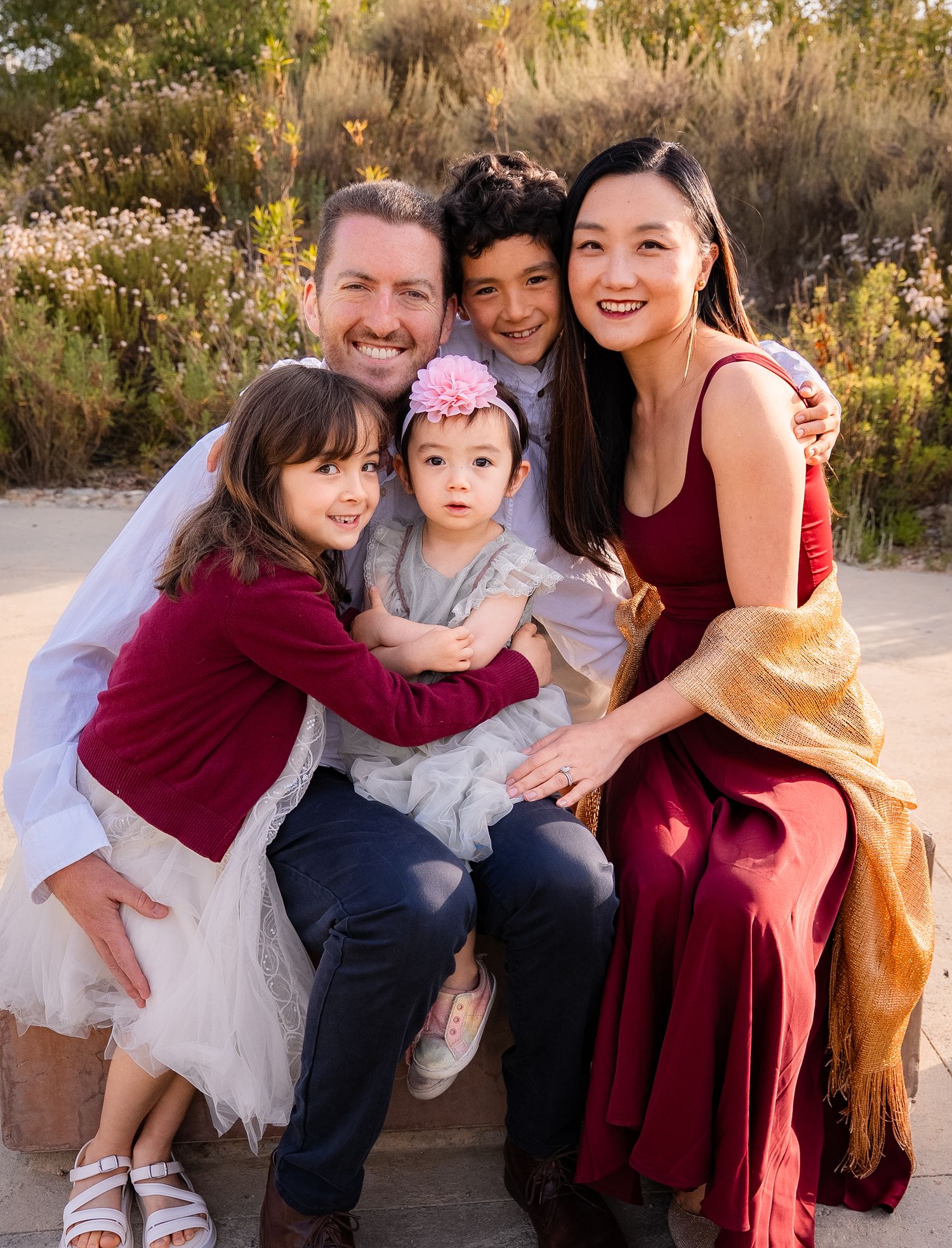 a loving natural portrait of a family of five all hugging each other during golden hour