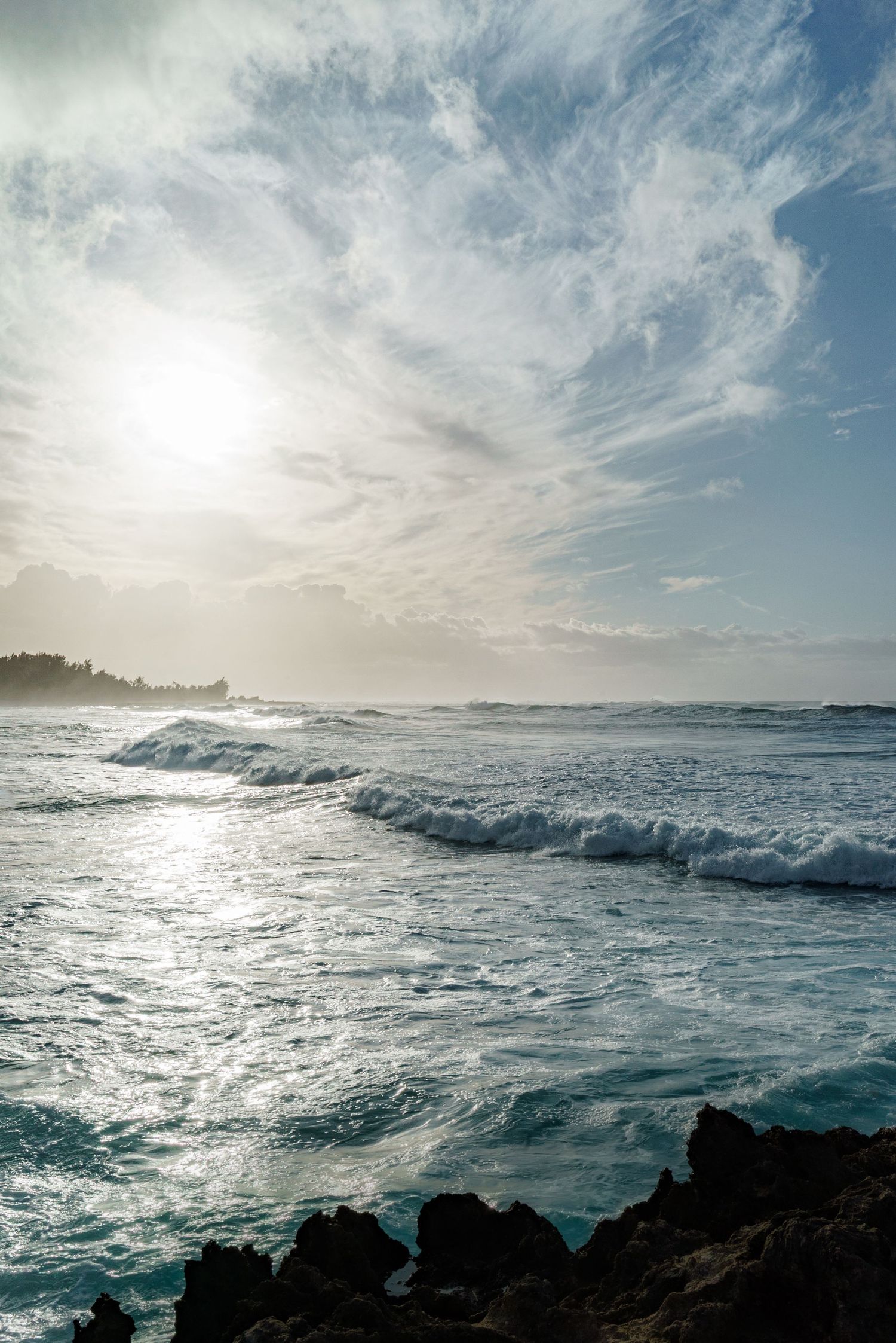 a landscape photo of the clouds, the setting sun and the ocean in hawaii at Sunset
