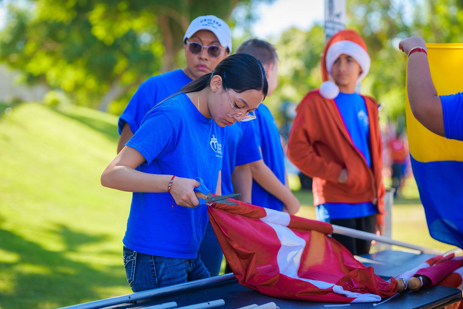 People in blue shirts participating in outdoor activities on a sunny day.
