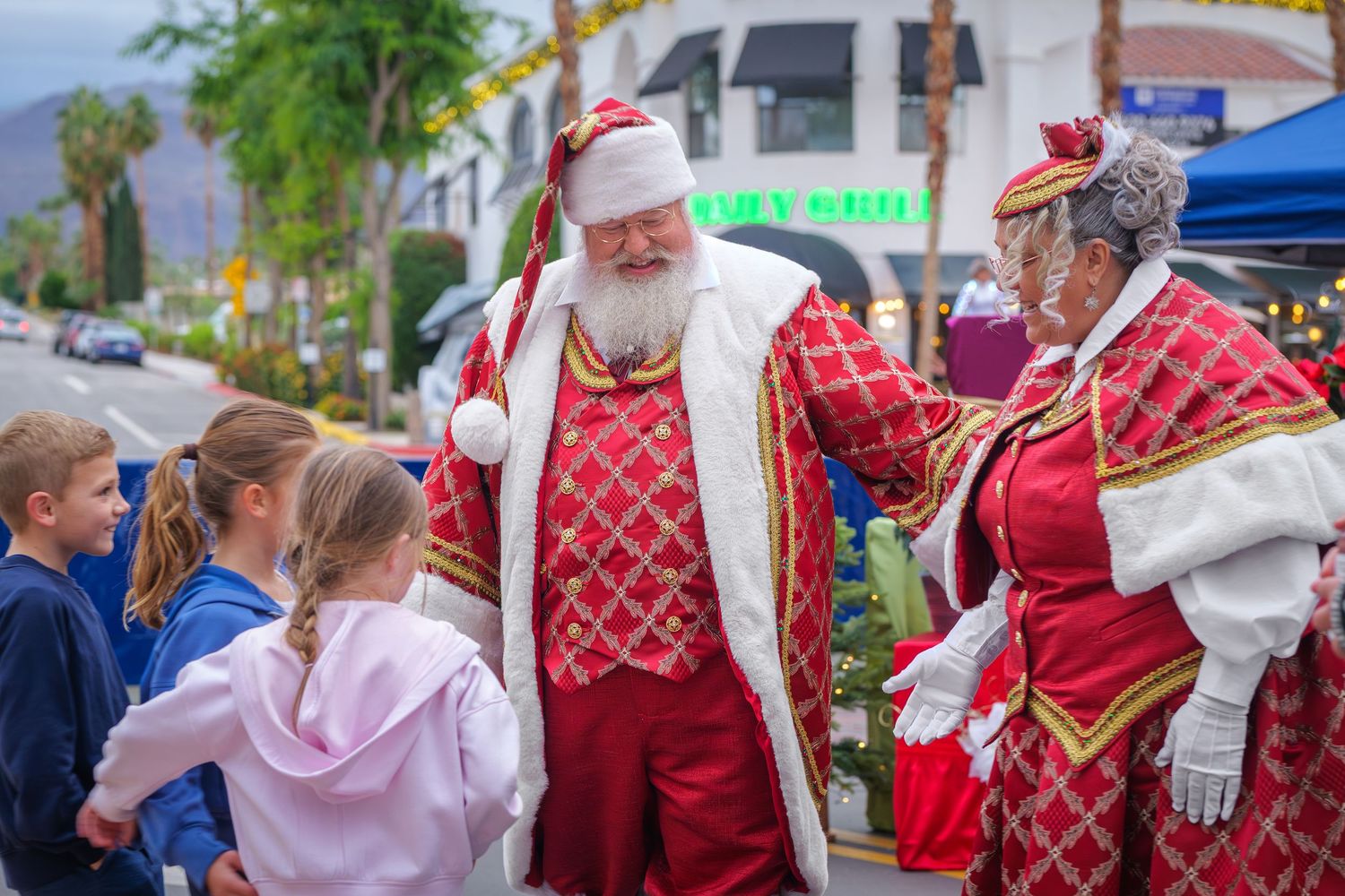 People in traditional red and white folk costumes dancing and celebrating at an outdoor cultural festival.