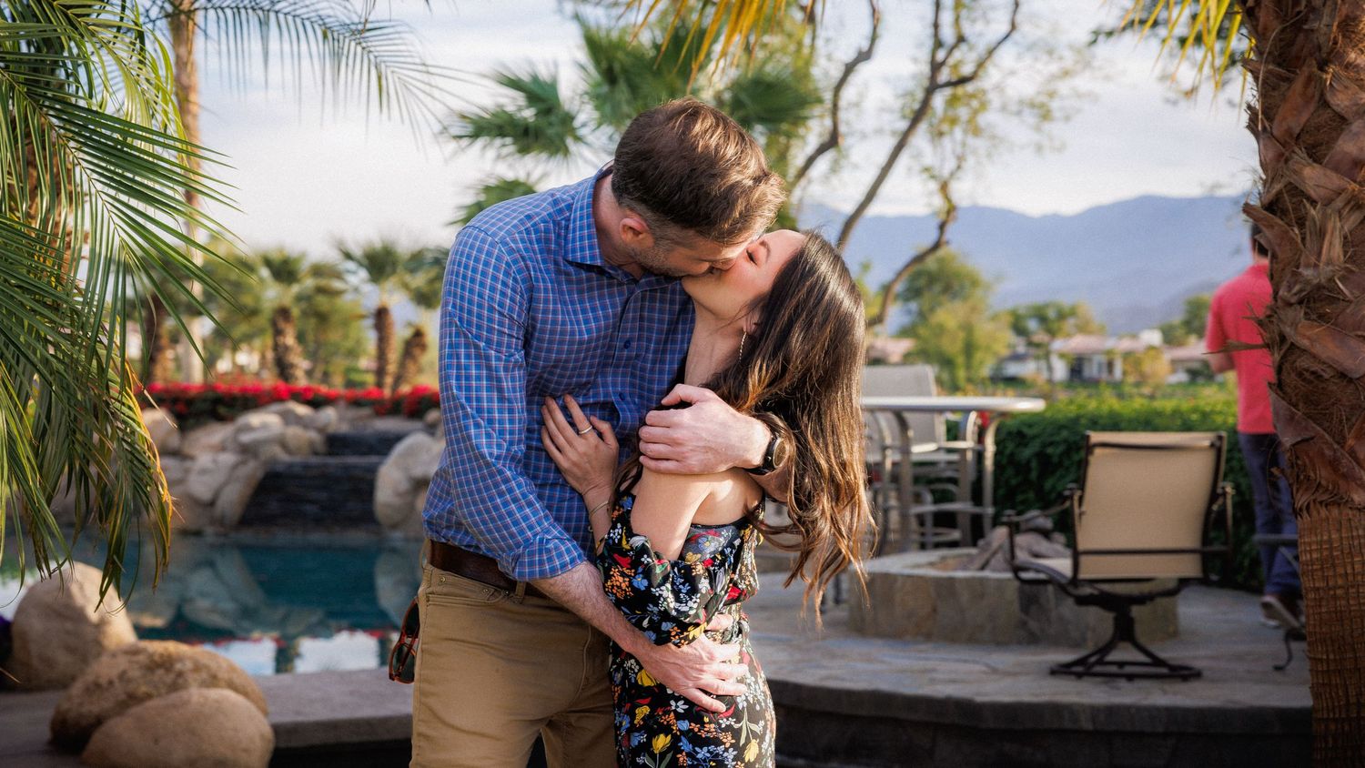 Outdoor venue with palm trees and mountains creating a scenic backdrop at sunset.