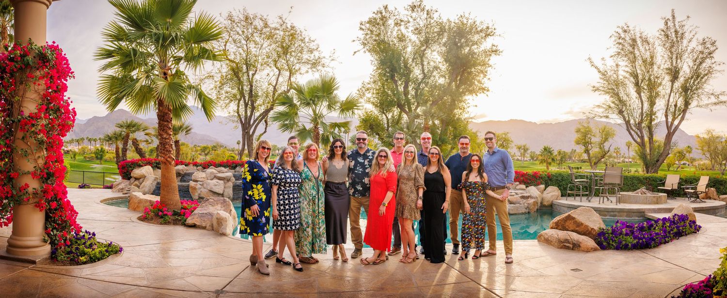 Palm trees and people gathering at an outdoor event during golden hour.