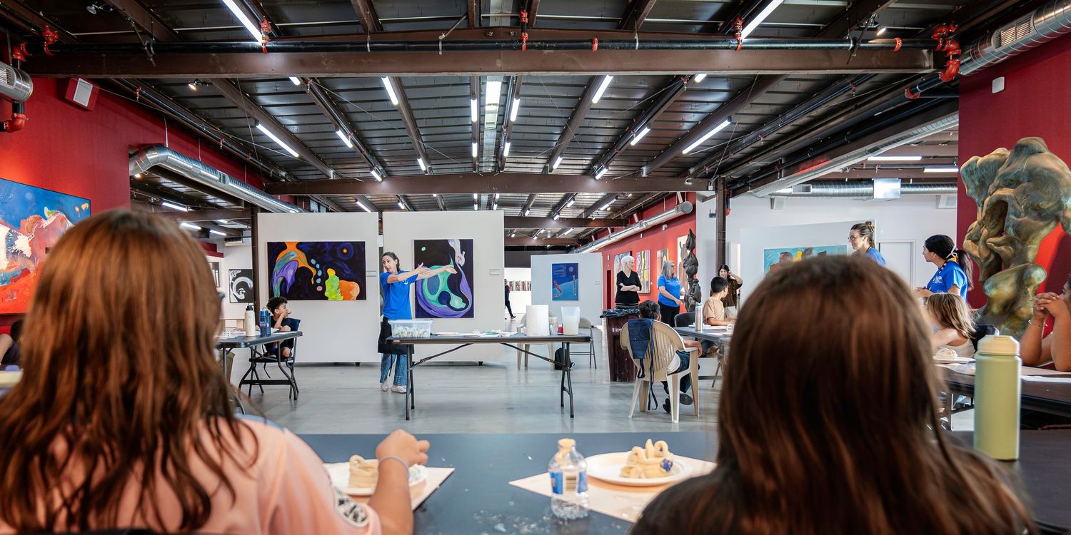 Conference attendees gathered in an industrial-style venue with red walls and overhead lighting.