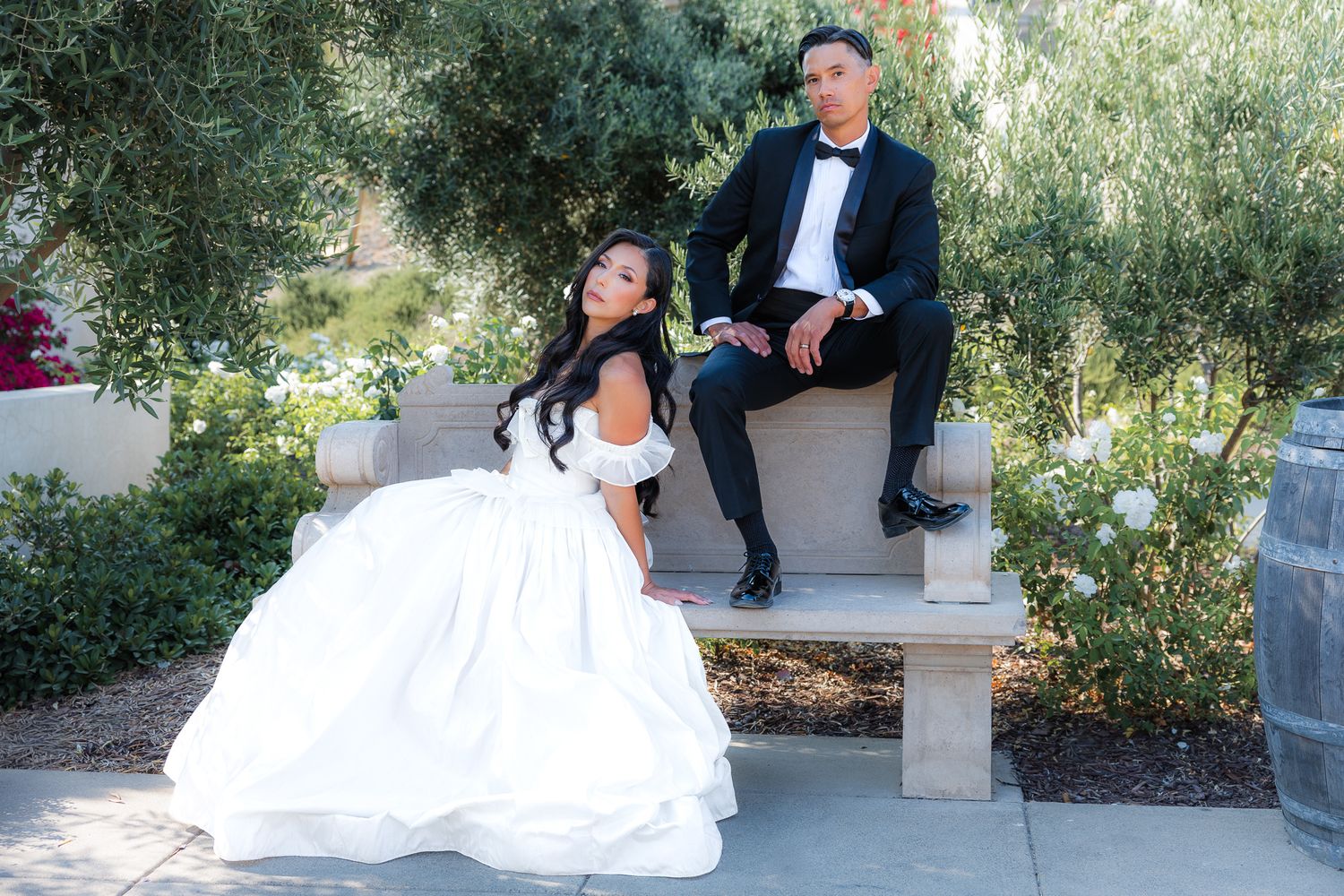 A couple poses together in a garden. Elevated wedding portraits. Bride and Groom portraits in luxury villa in Southern California.