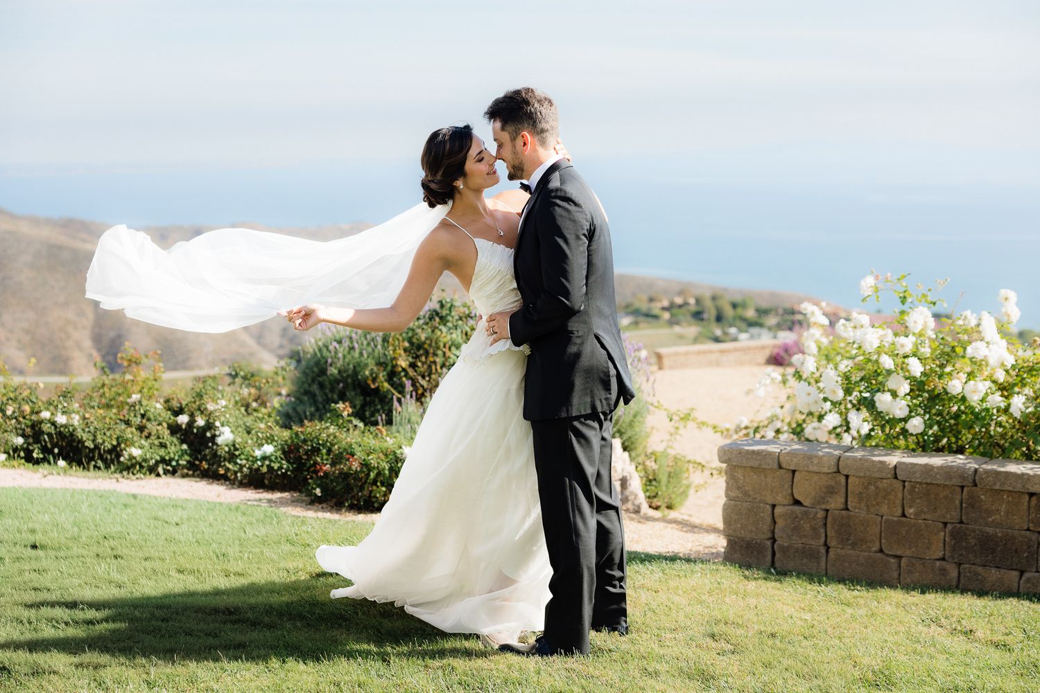 bride and groom cinematic, dramatic kiss with the veil blowing in the wind.