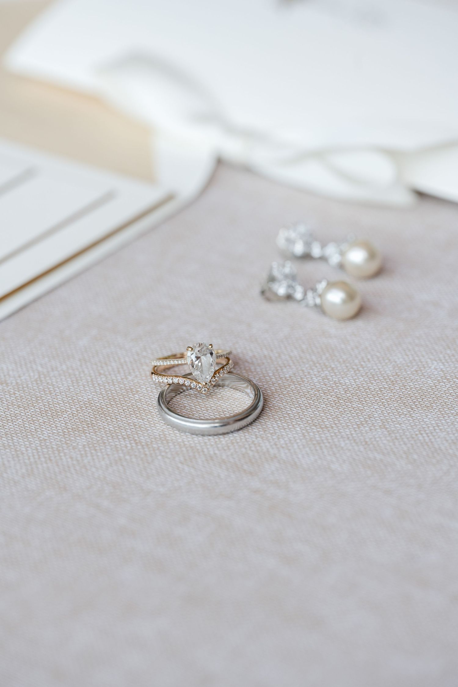 Elegant diamond engagement rings displayed on a neutral linen background.