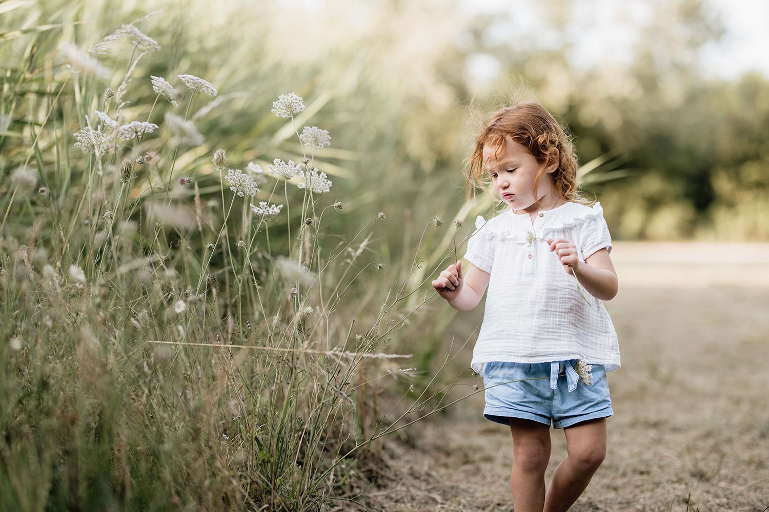 A series of candid outdoor photographs showing a child playing in a natural setting with wildflowers and tall grass.