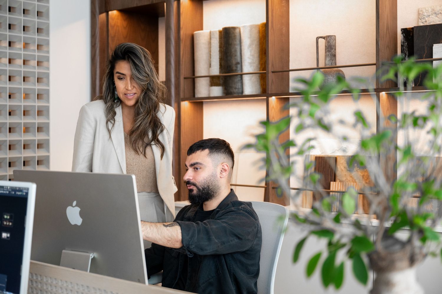 Collaborative workspace with people using laptops and natural lighting through windows.