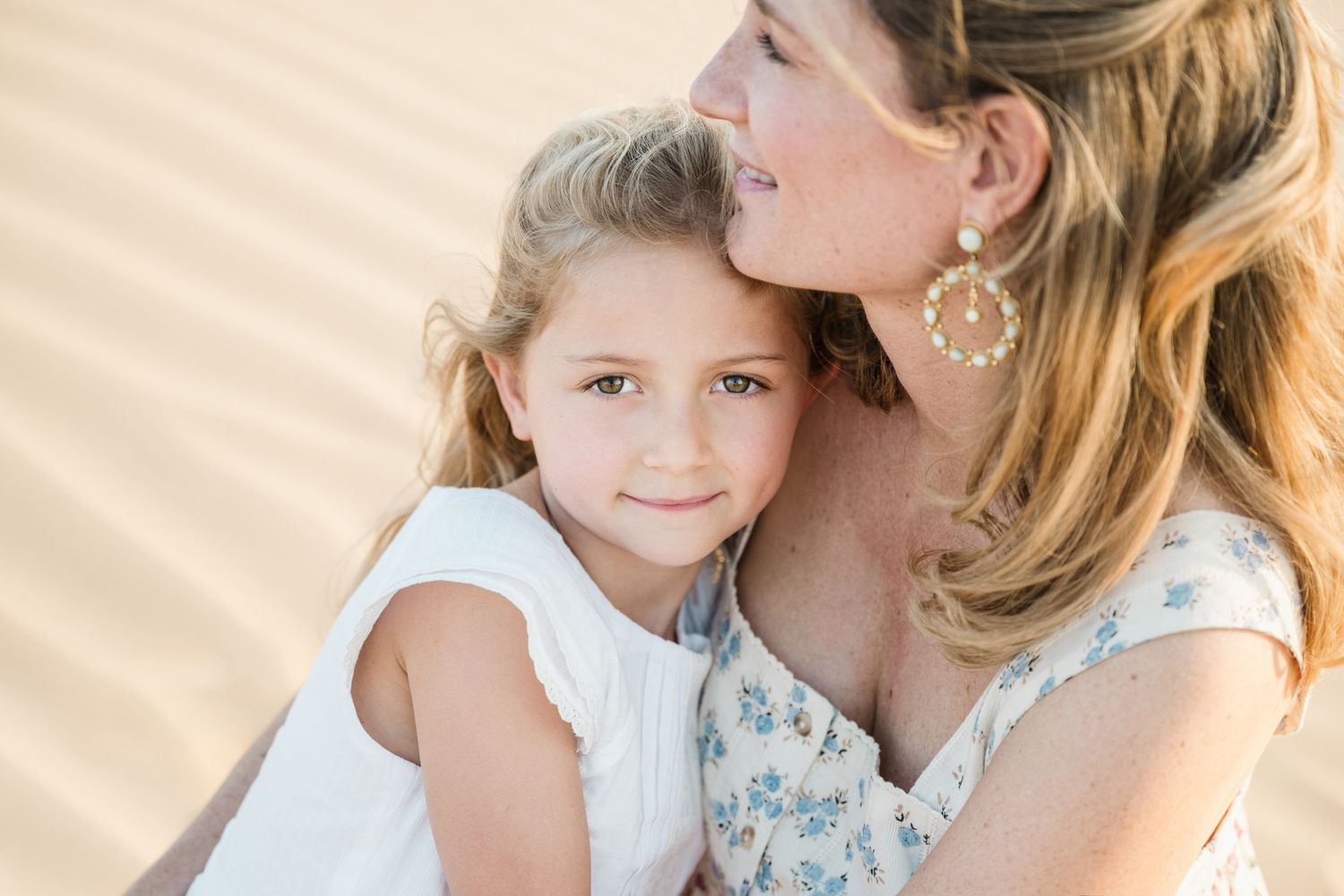 Tender moment between parent and child on desert sand dunes.
