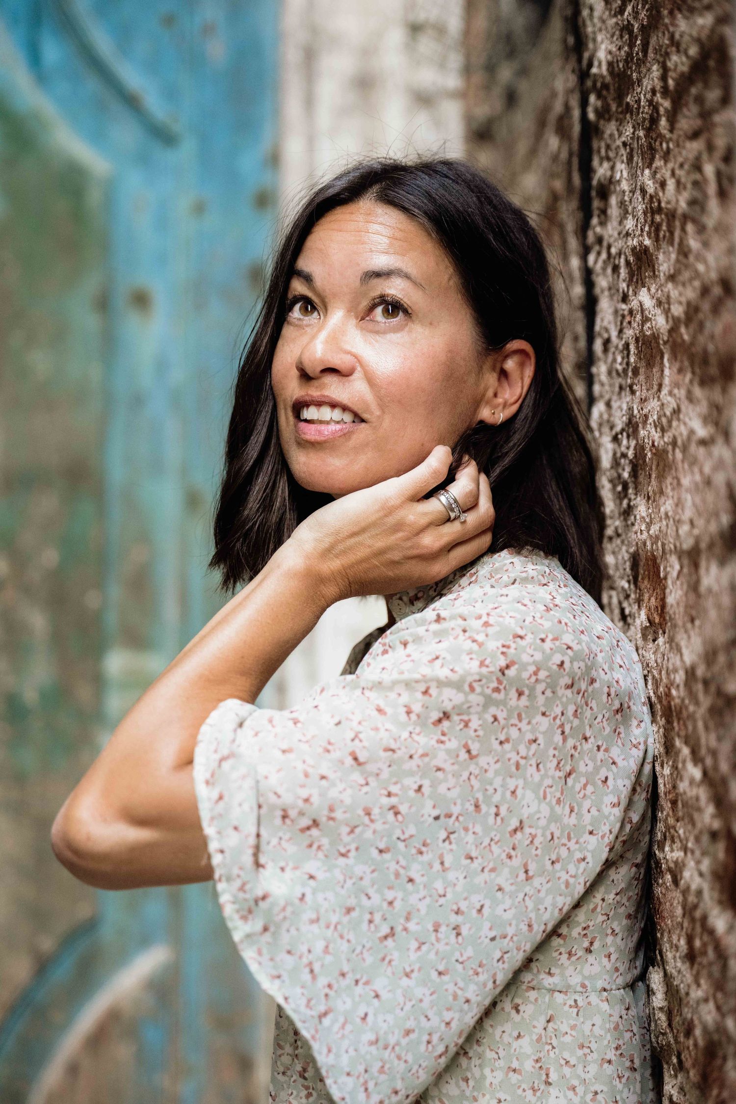 Candid fashion portraits against weathered stone wall and turquoise door in Venice.