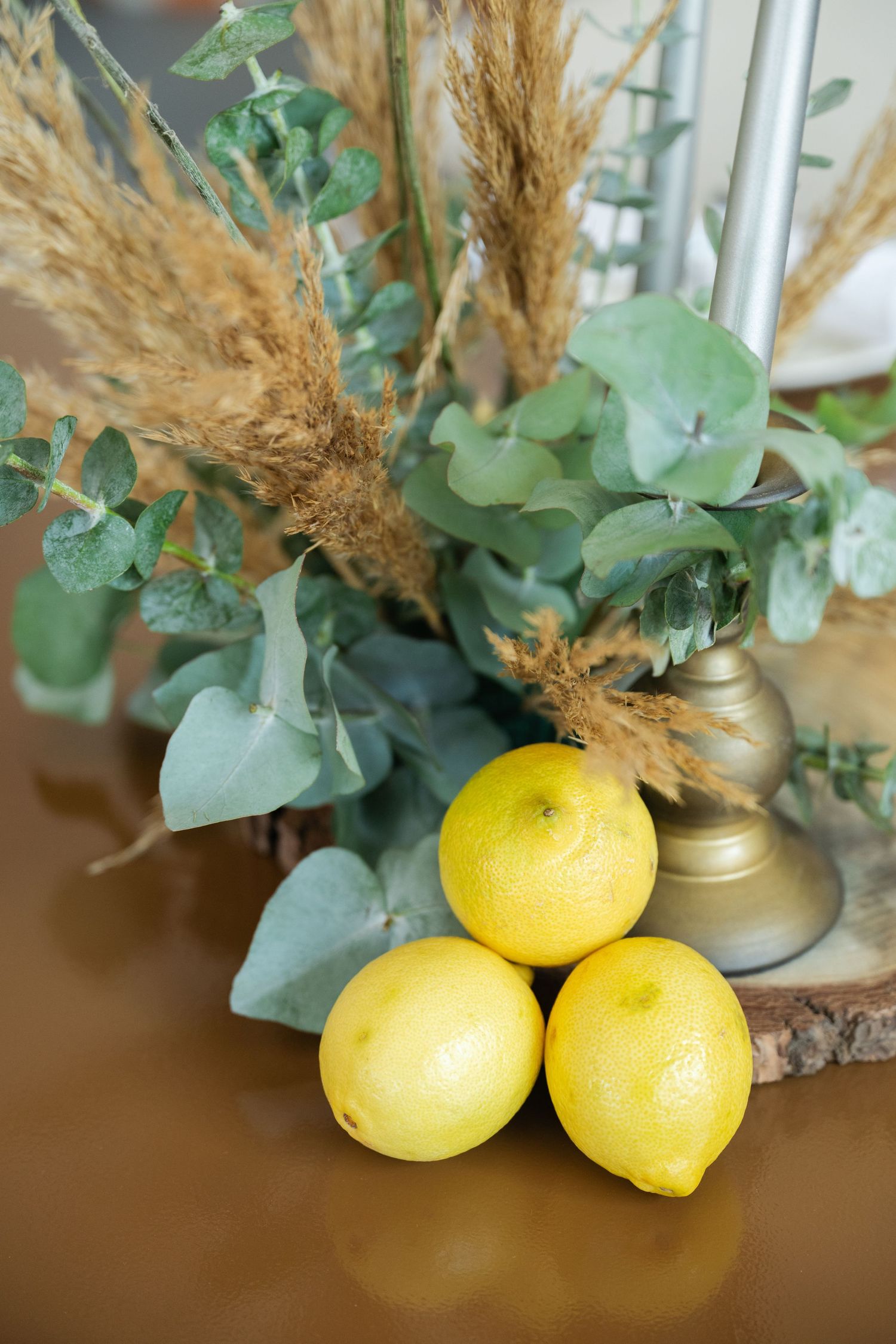 Fresh yellow lemons and eucalyptus leaves arranged as natural wedding decor elements.