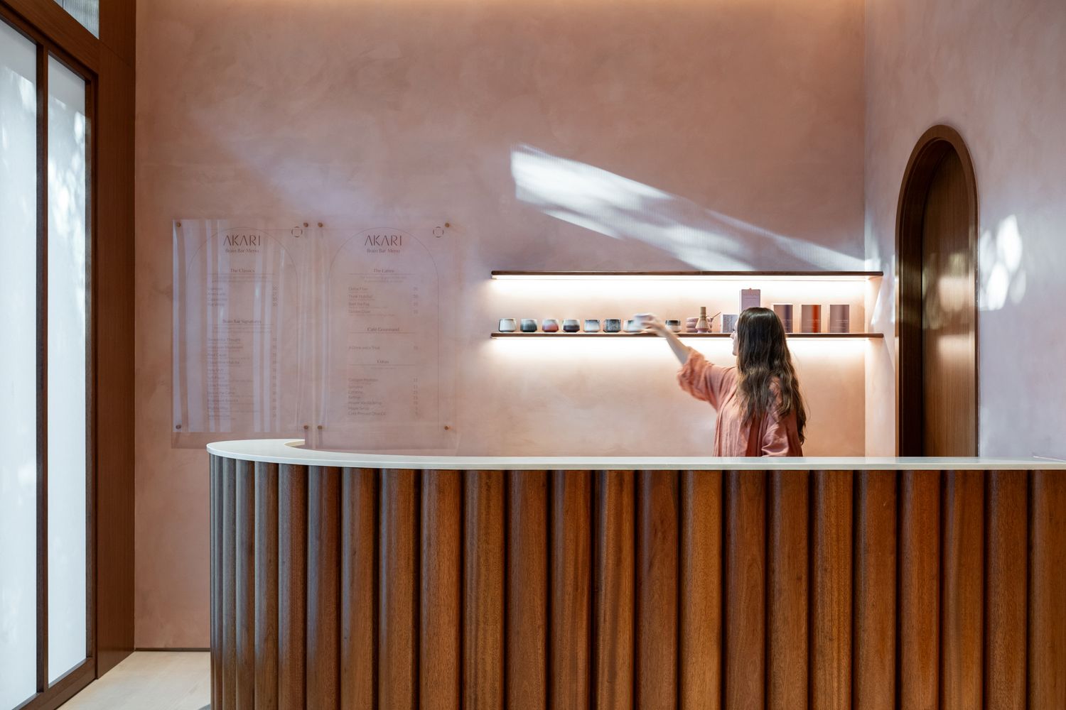 Modern interior hallway with wooden slat wall paneling and recessed lighting creating a warm architectural aesthetic.