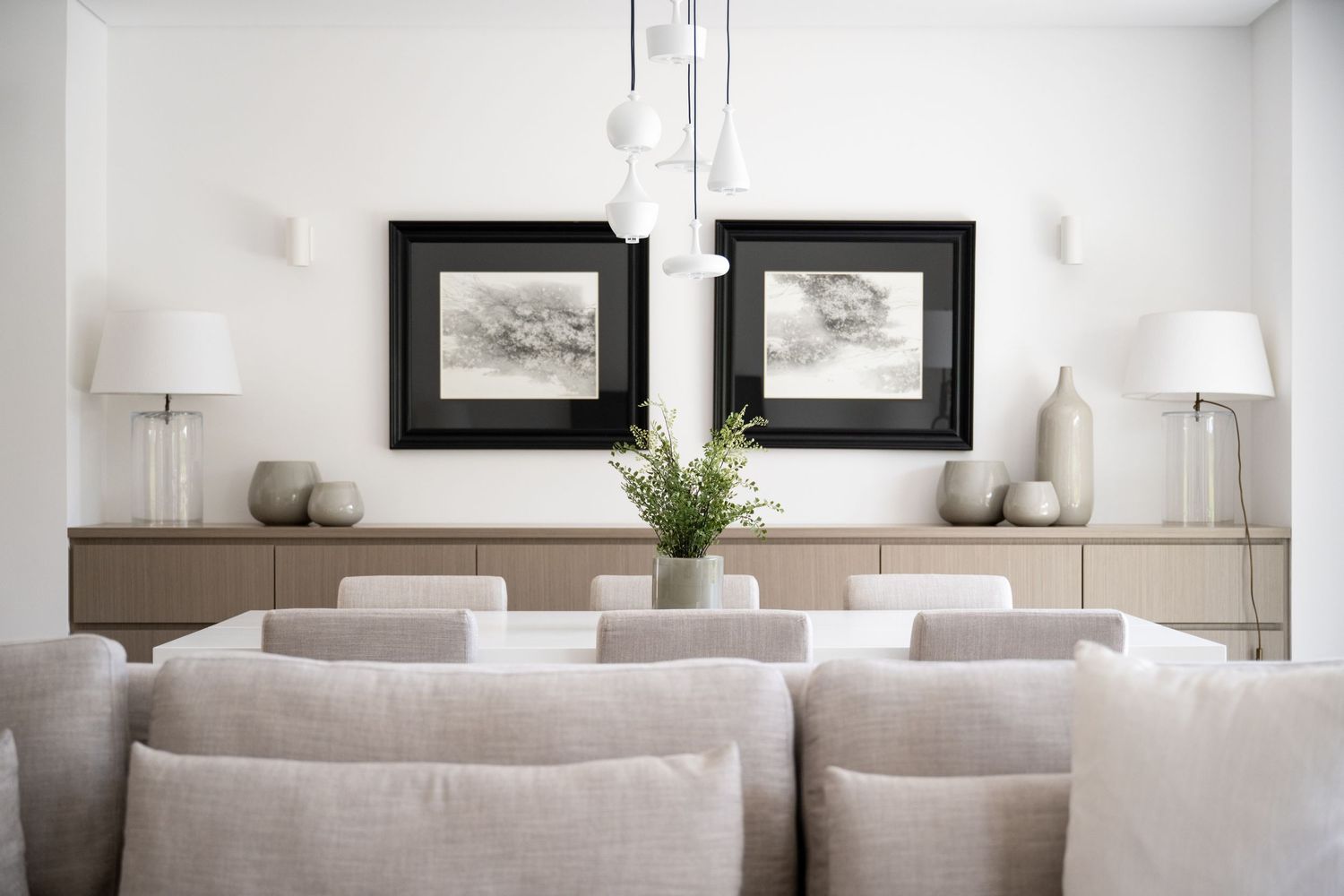 Contemporary living room with neutral tones featuring gray sofas and black framed artwork.