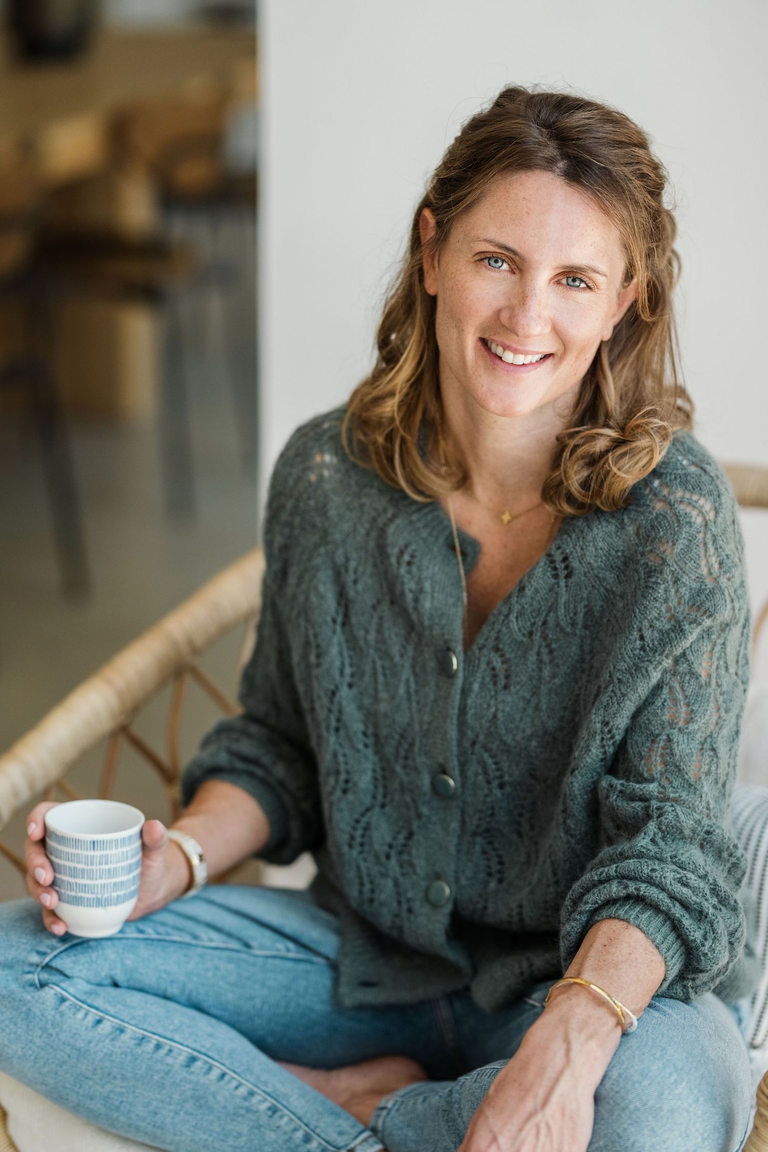 Casual lifestyle photos of woman in green sweater holding coffee cup and relaxing.