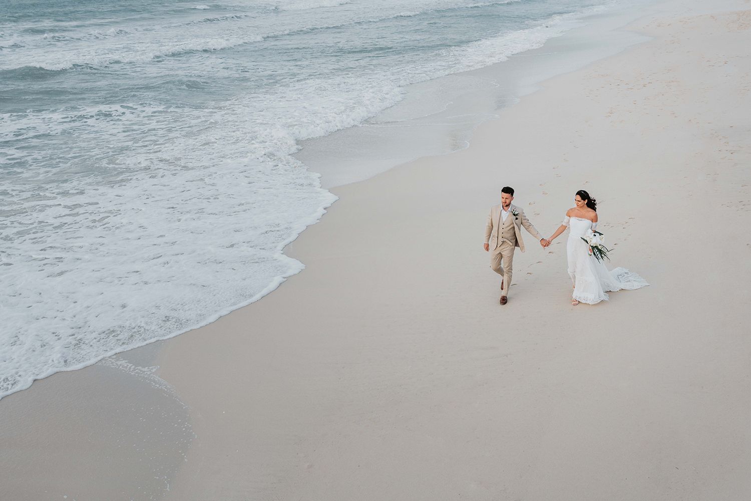 Serene beach scene with gentle waves rolling onto white sand.
