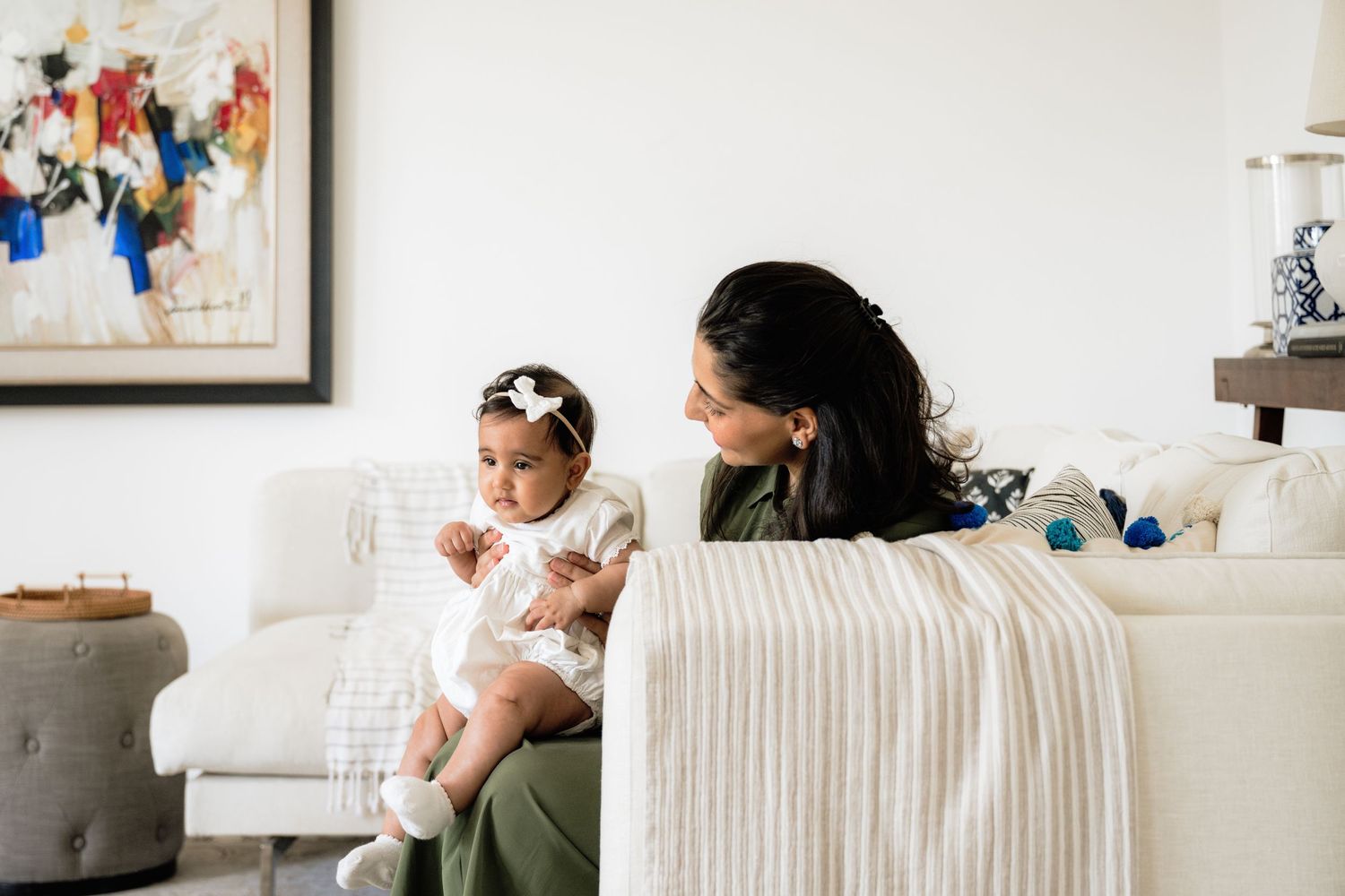 Intimate family moments captured in bright modern living room with white furniture.