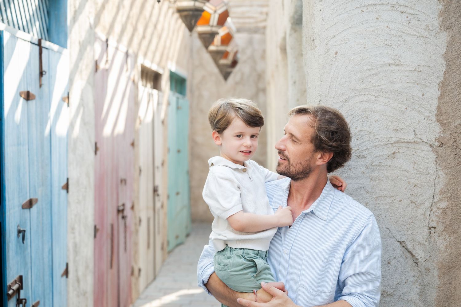 Family photoshoot in a rustic stone hallway with blue doors.