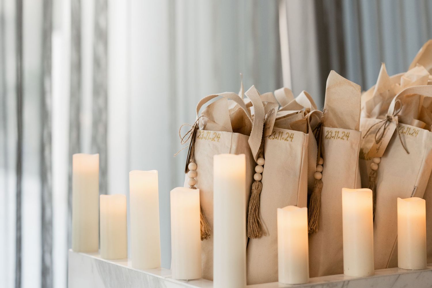 Line of white pillar candles creating romantic ambiance at evening event.
