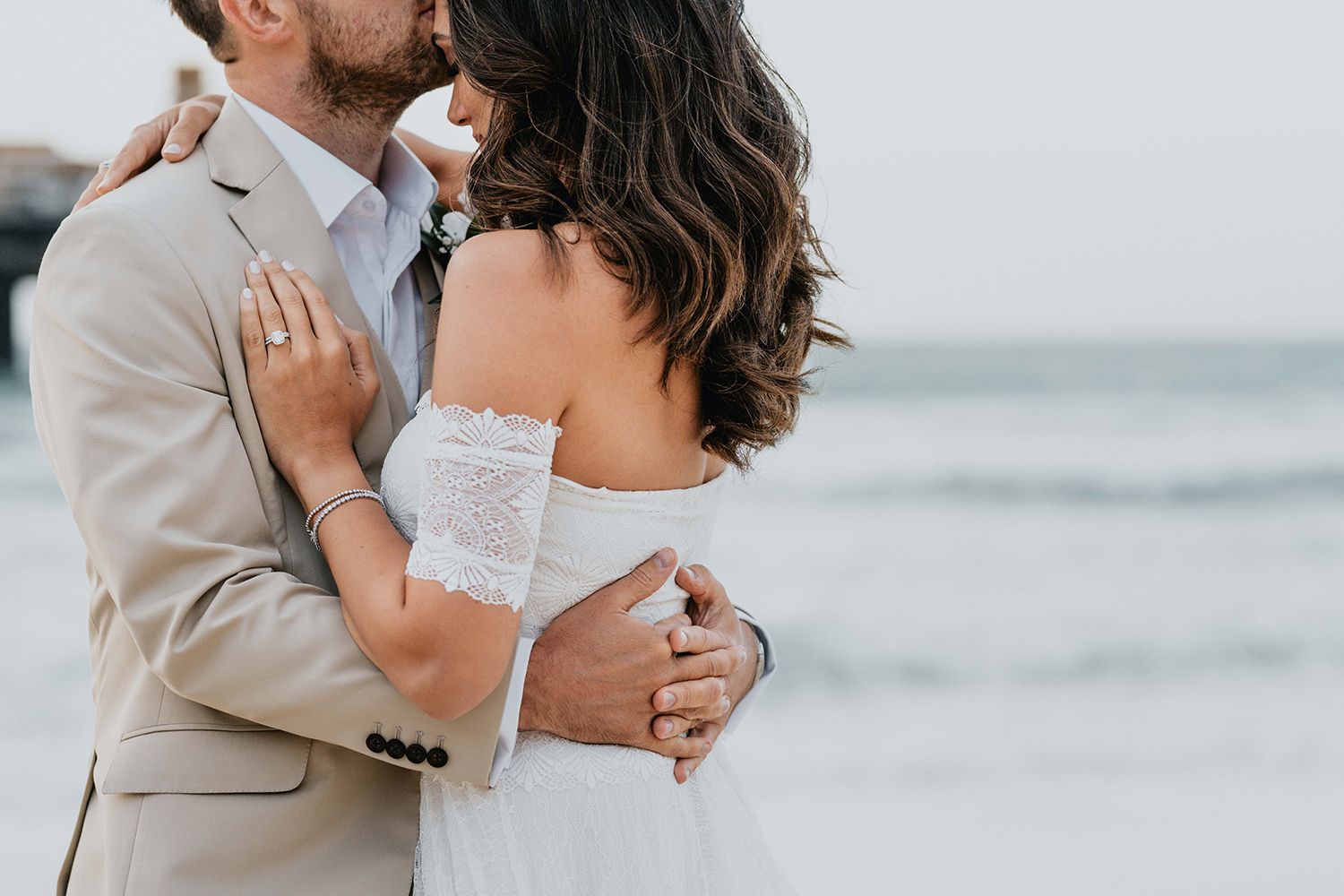 Close-up romantic moments captured during a beachside wedding photoshoot.