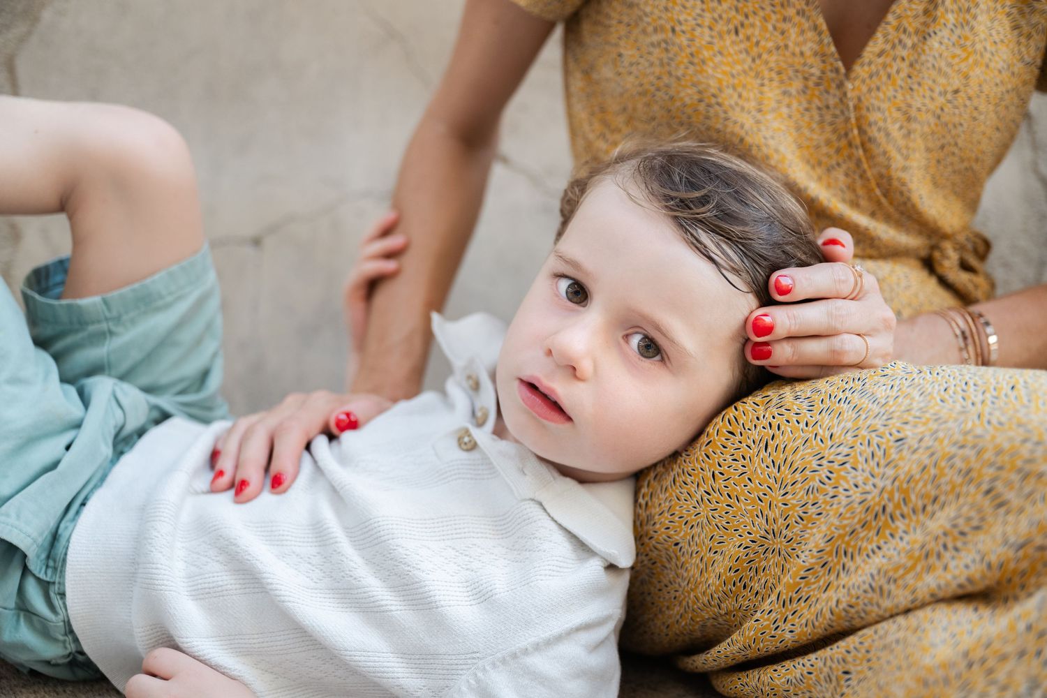 Sweet family moment captured in casual clothing against neutral backdrop.