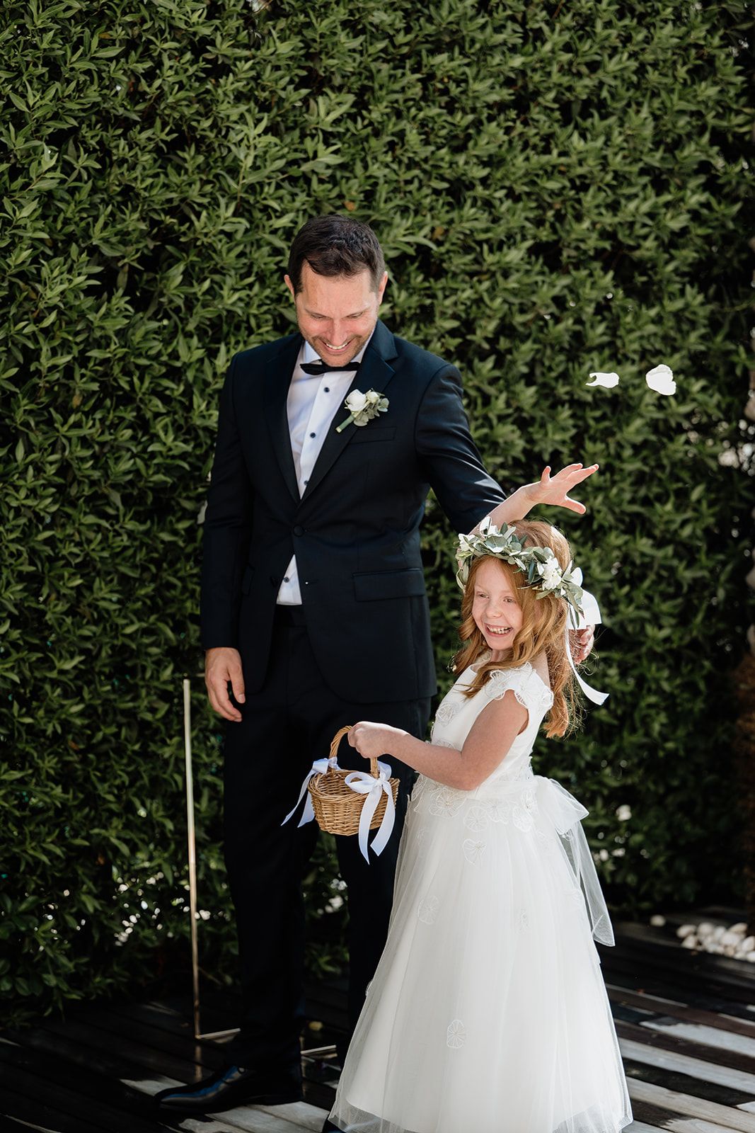 Flower girl in white dress twirling during wedding celebration.