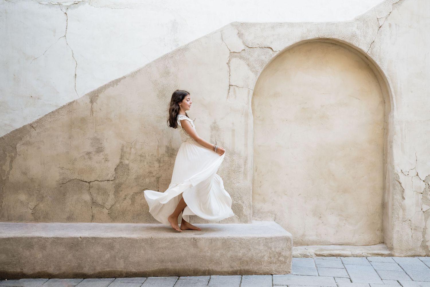 Artistic photo sequence against white stone walls showing movement and grace.