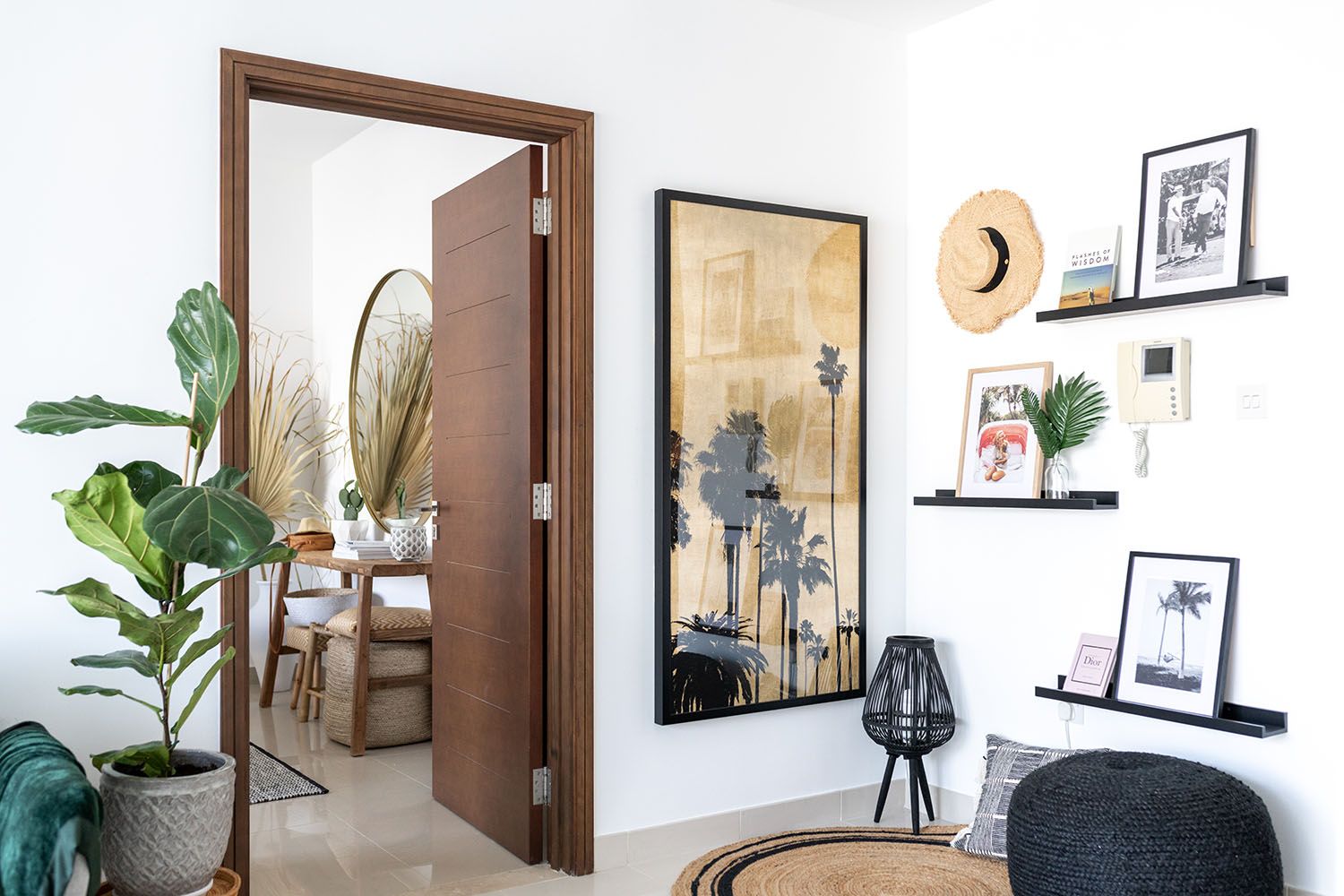 Gallery wall with black and white prints in wooden frames against white walls.