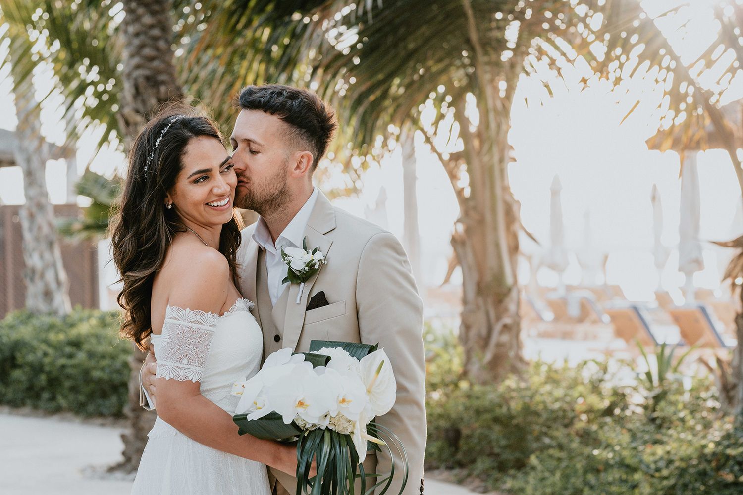 A romantic beach wedding photoshoot with palm trees and ocean views.