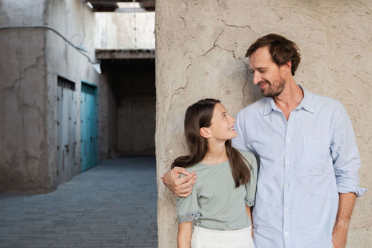 A couple shares intimate moments against a textured wall background.