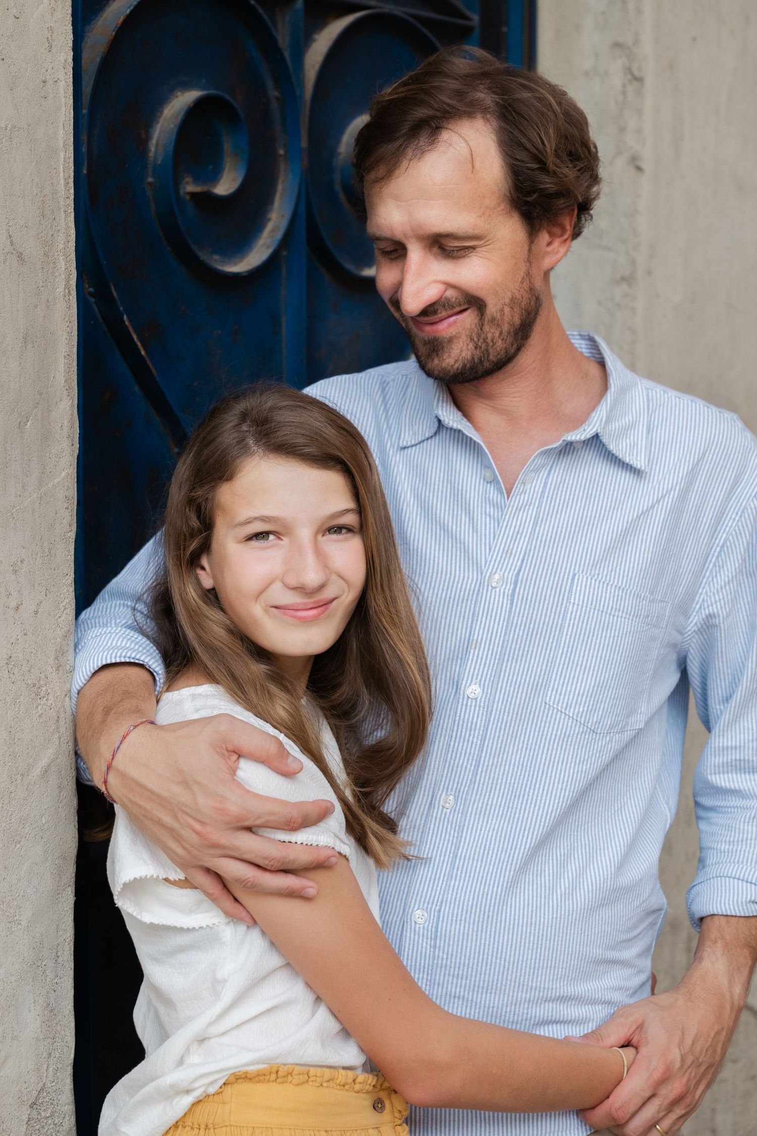 Heartwarming embrace between parent and child against blue door background.