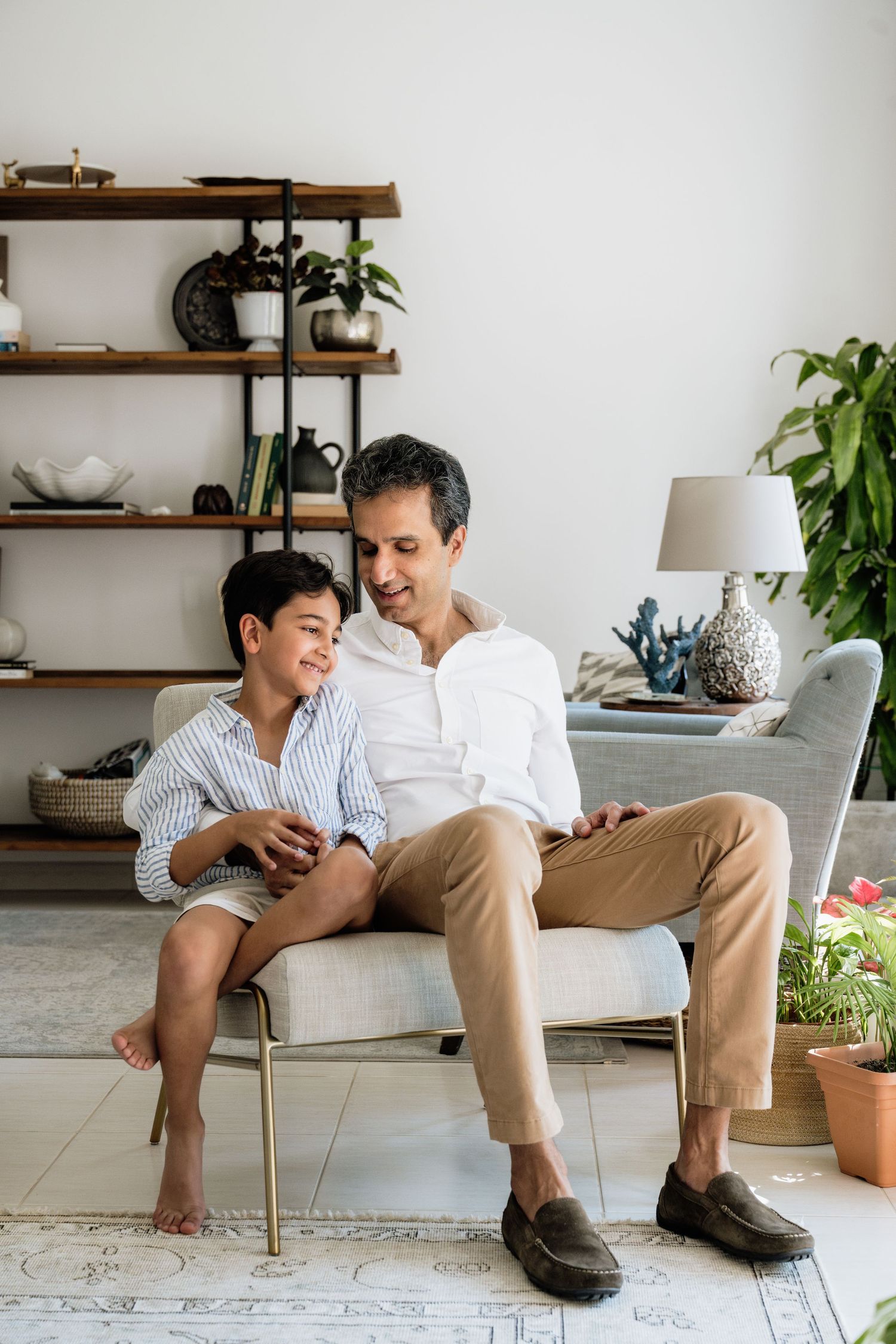 Modern interior lifestyle photos with wooden shelving and plants in a bright white space.