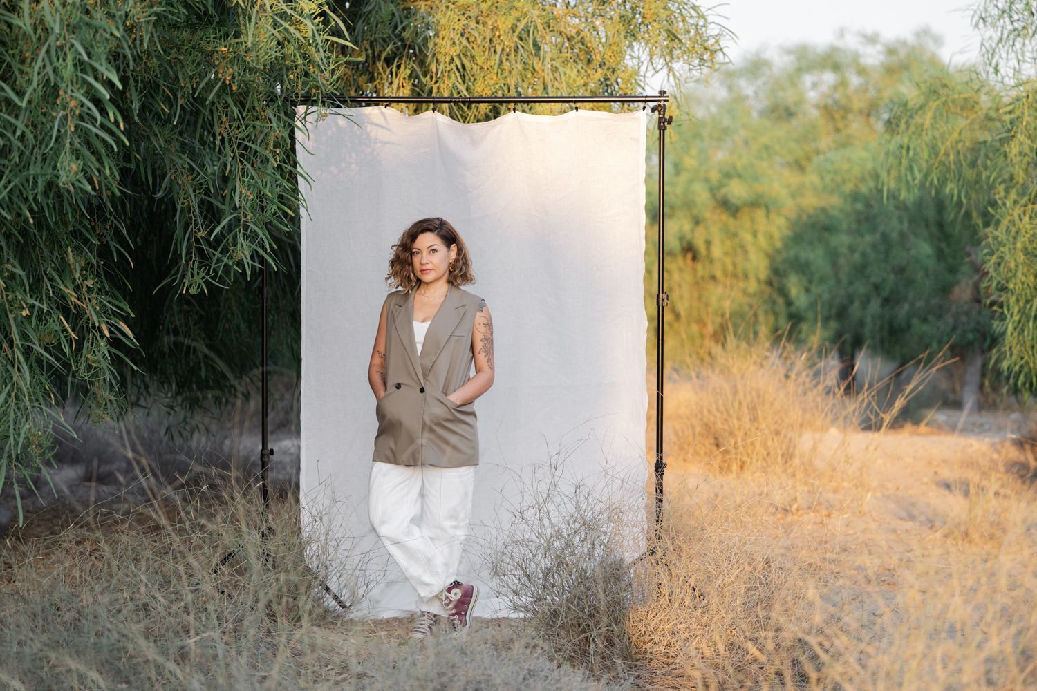 Outdoor portrait session in golden and green spot with warm sunset lighting and natural backdrop.