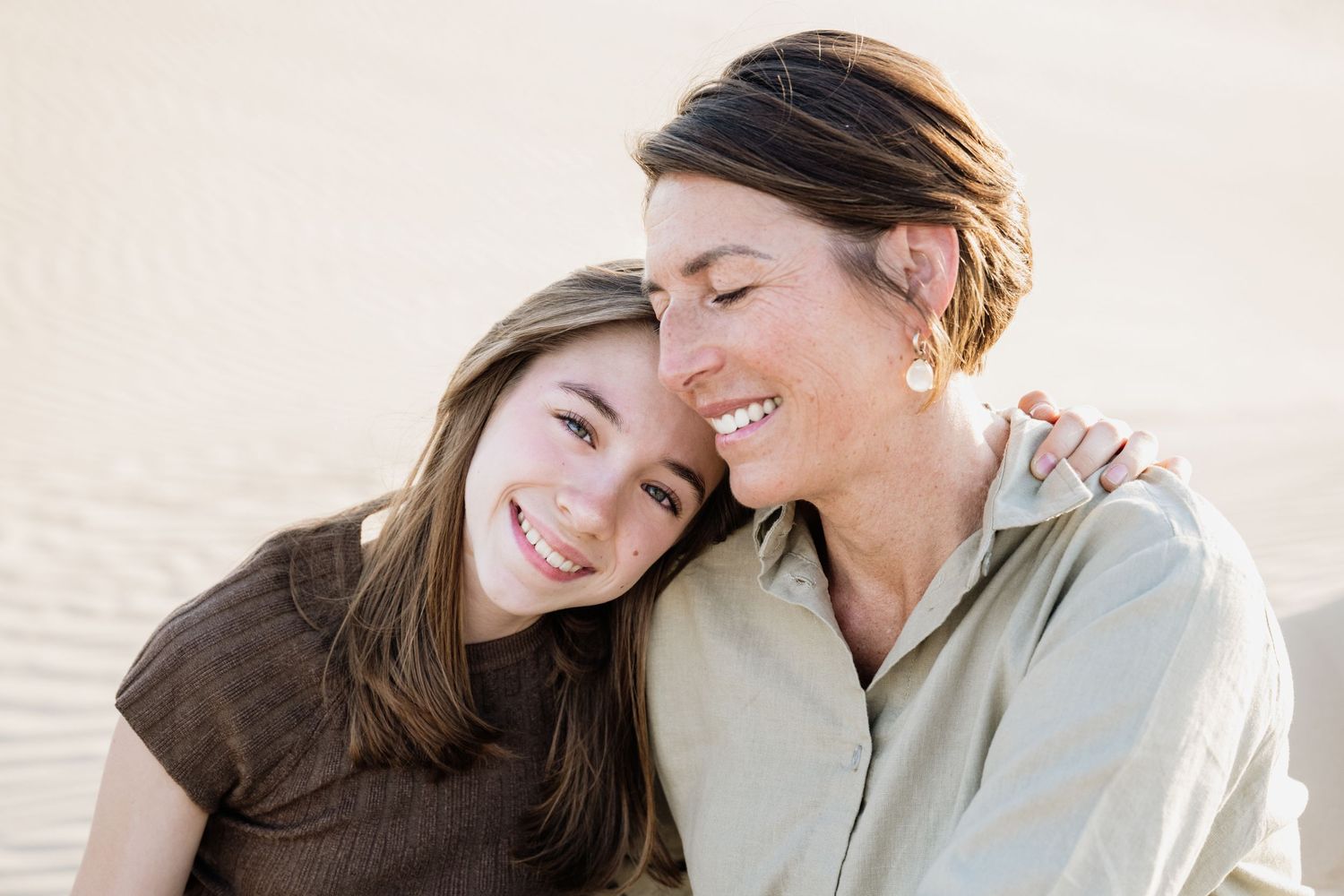 Intimate candid moments captured between people on desert sand dunes.