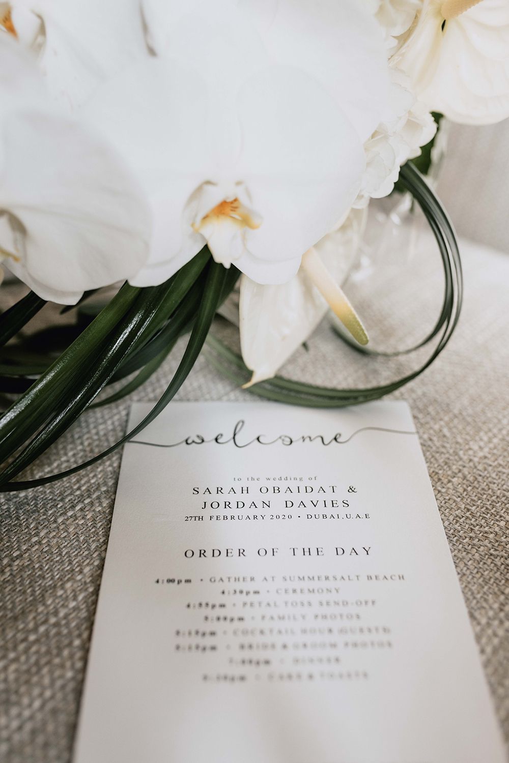 Elegant wedding invitation suite with white orchids and minimalist typography.