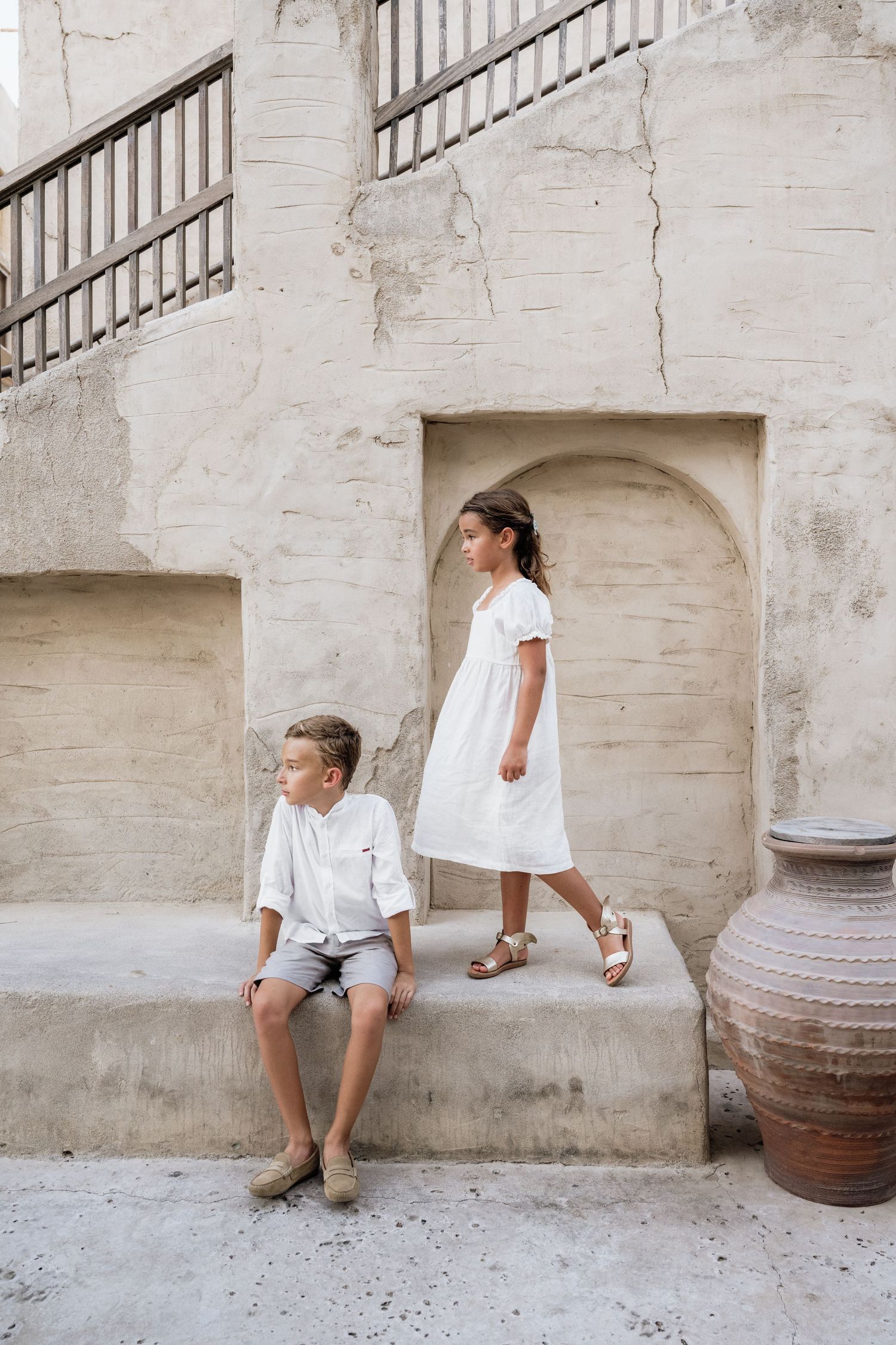 A minimalist photoshoot against white stone walls with rustic pottery details.