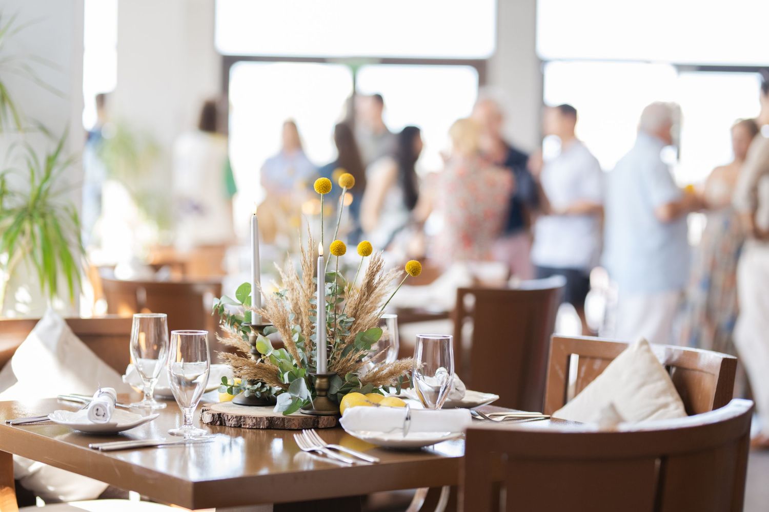 Light-filled wedding reception venue with elegant table settings and natural decor.