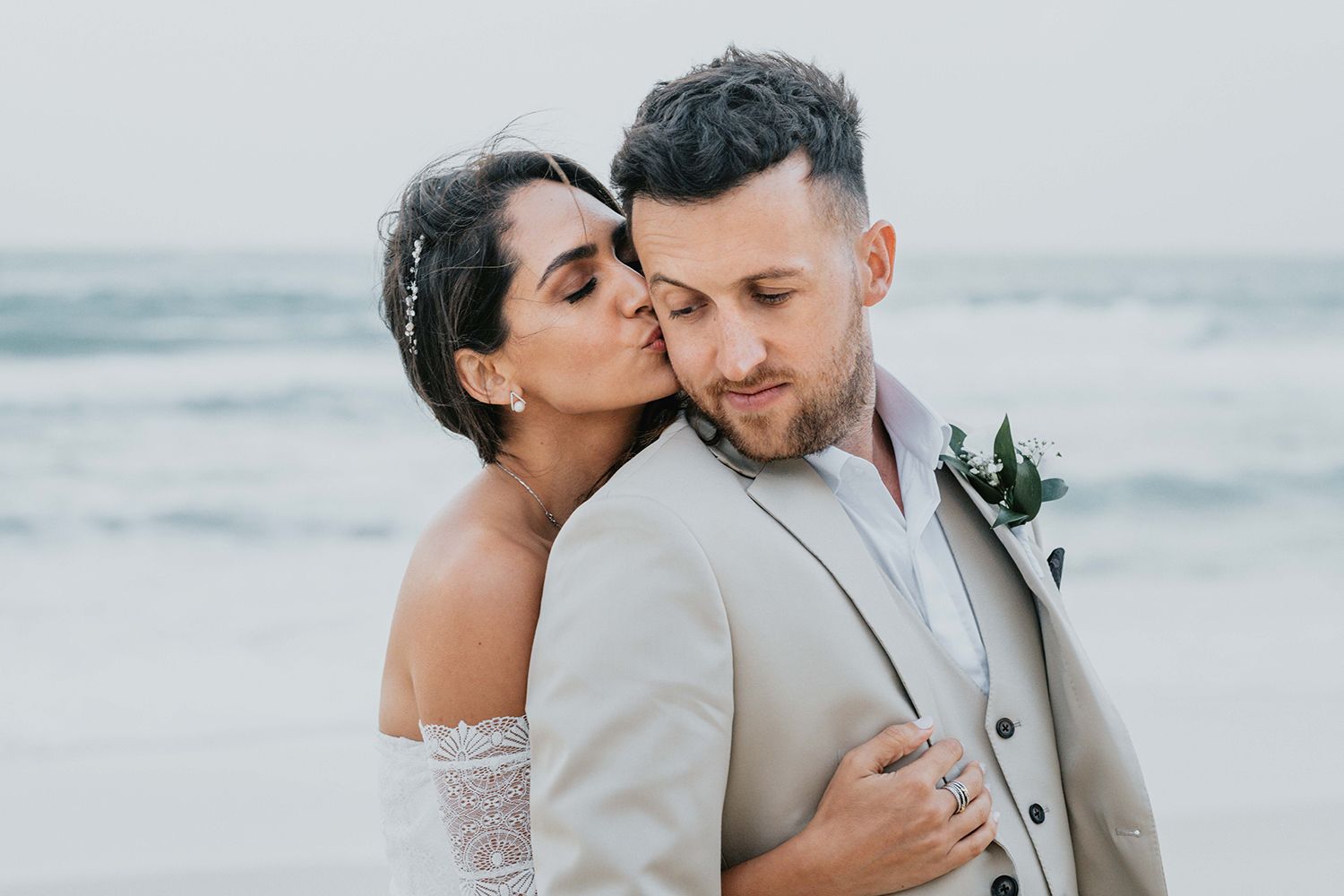 A romantic beach wedding photoshoot with the couple sharing intimate moments by the ocean.