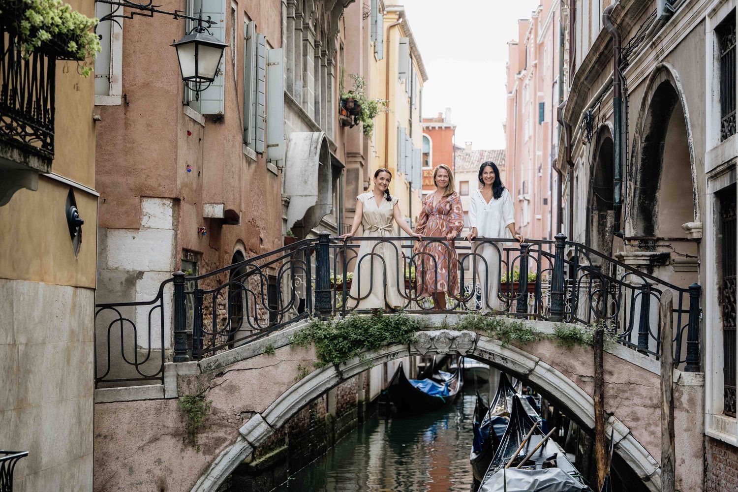 Narrow Venetian canal with stone bridge and traditional architecture in soft lighting.
