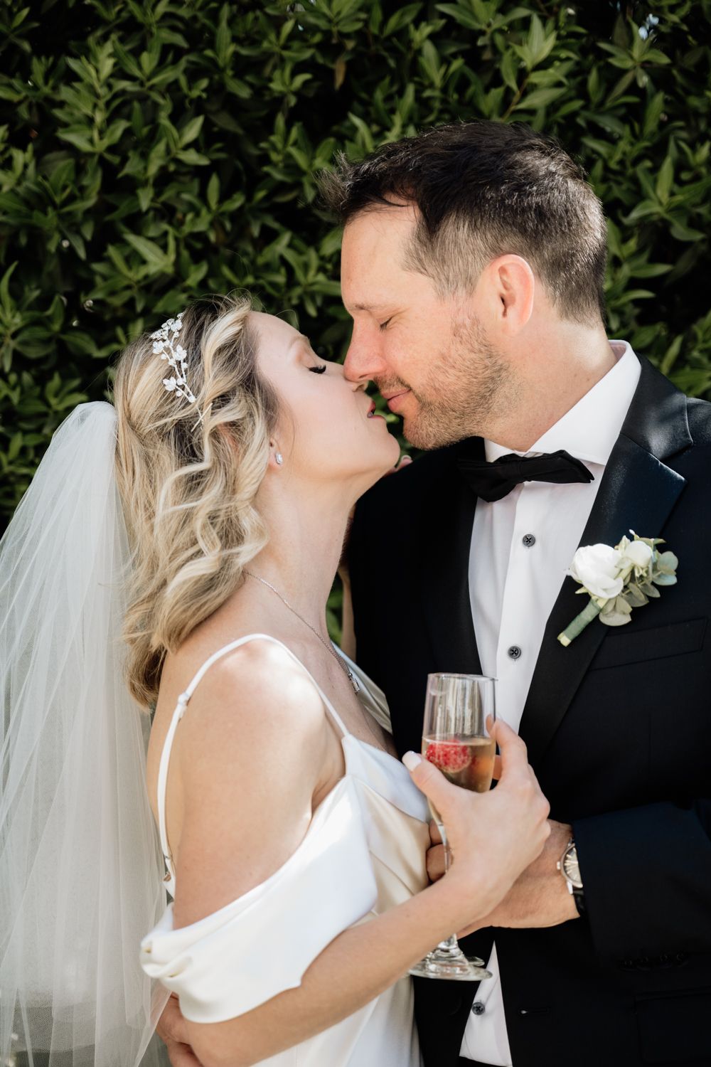 Small wedding garden ceremony couple kissing with champagne