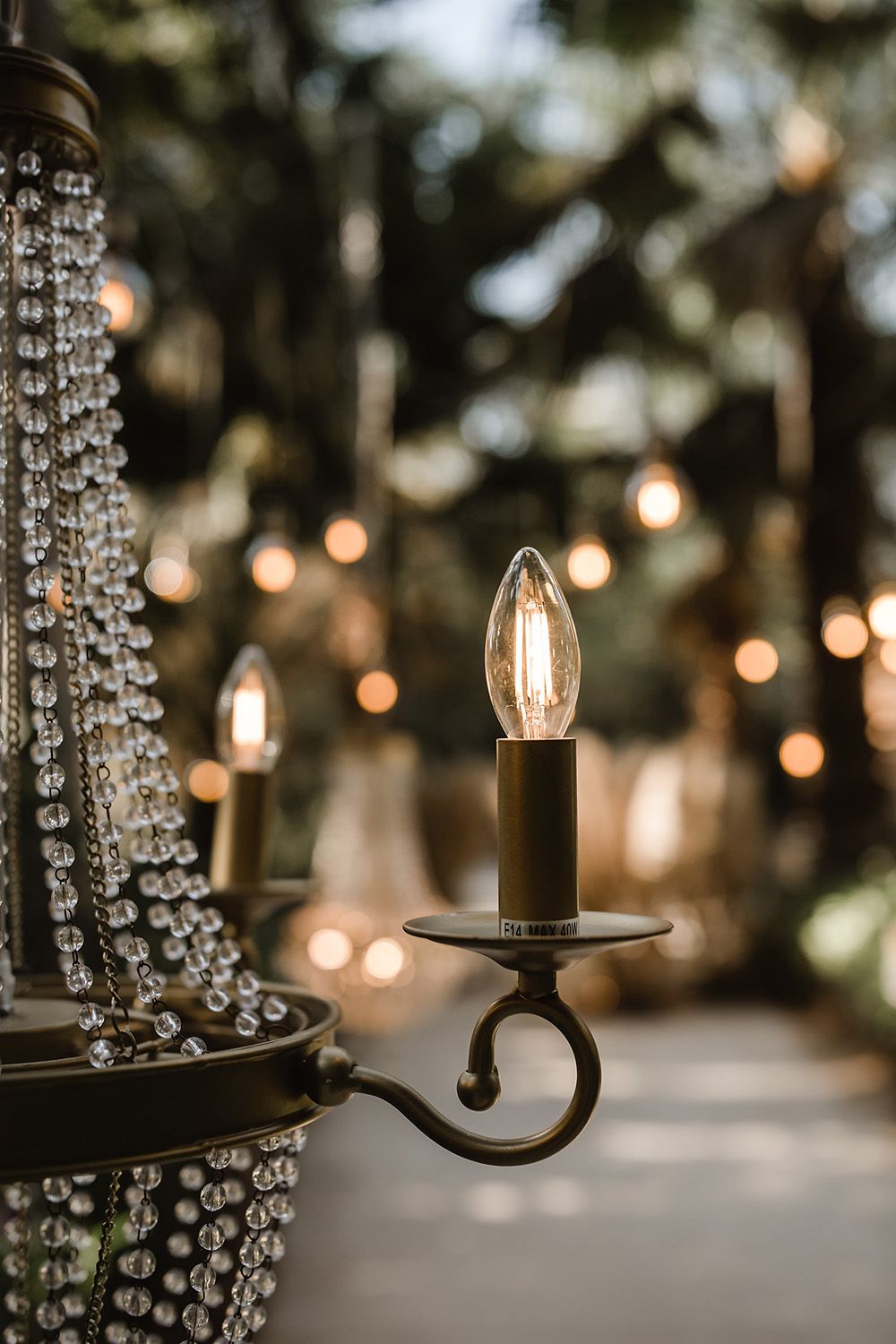 Crystal chandelier with glowing candle light fixture in romantic setting.