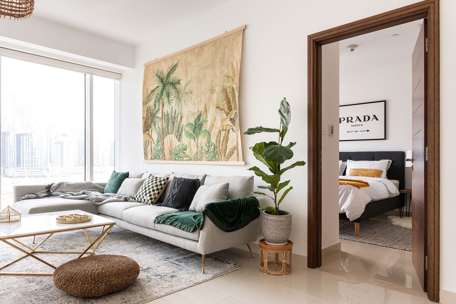 Minimalist bedroom with tropical art, white walls, and modern decor elements.