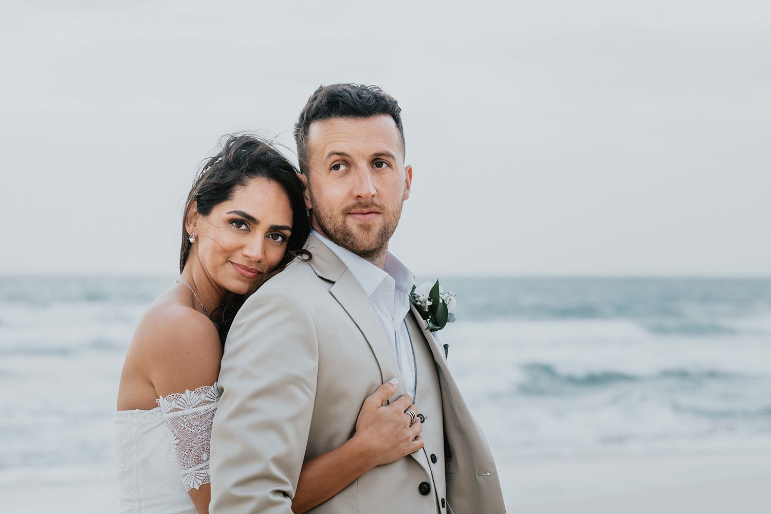 Romantic beach wedding portraits with soft lighting and ocean backdrop.