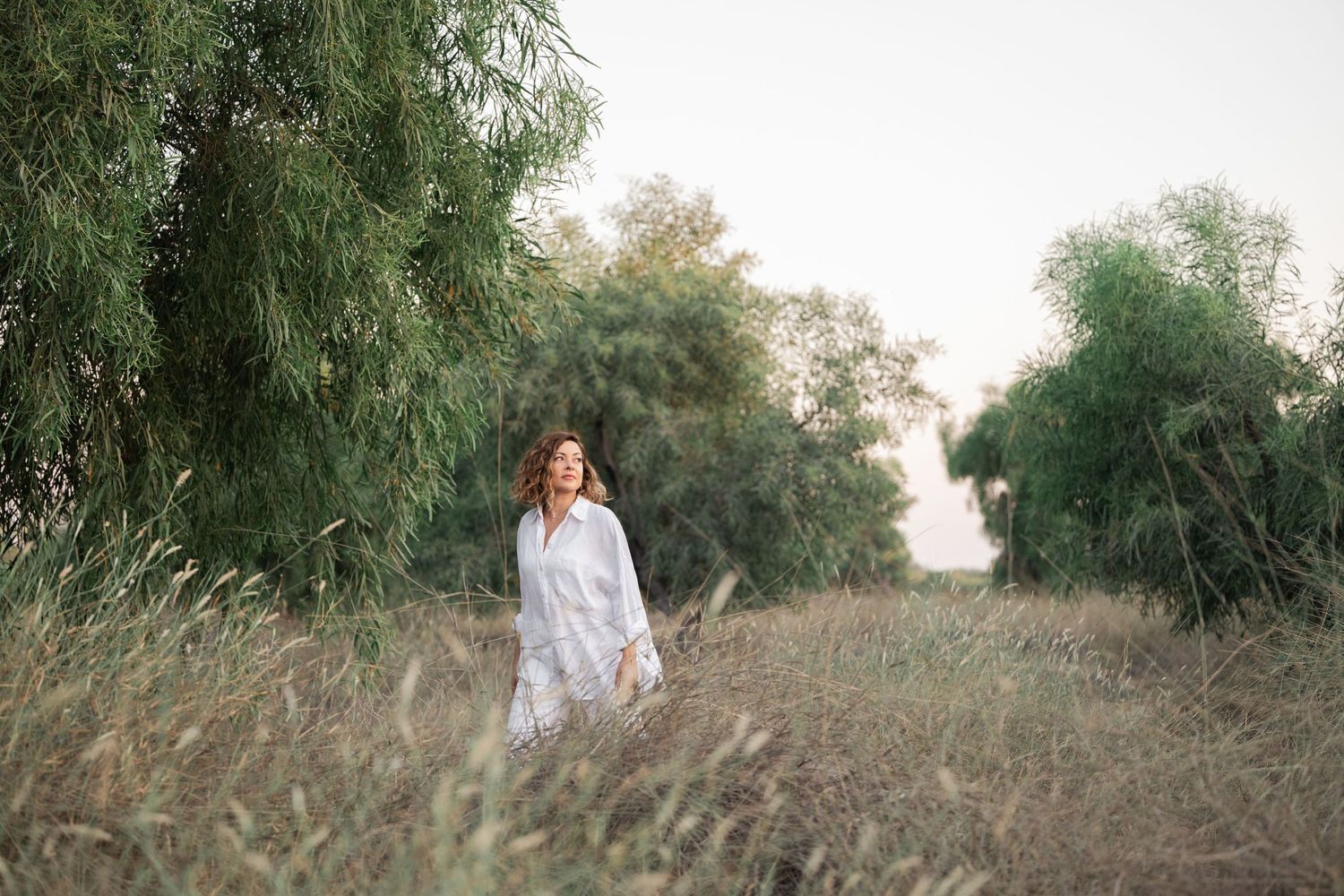 Natural light portraits in field with white backdrop and flowing dress.