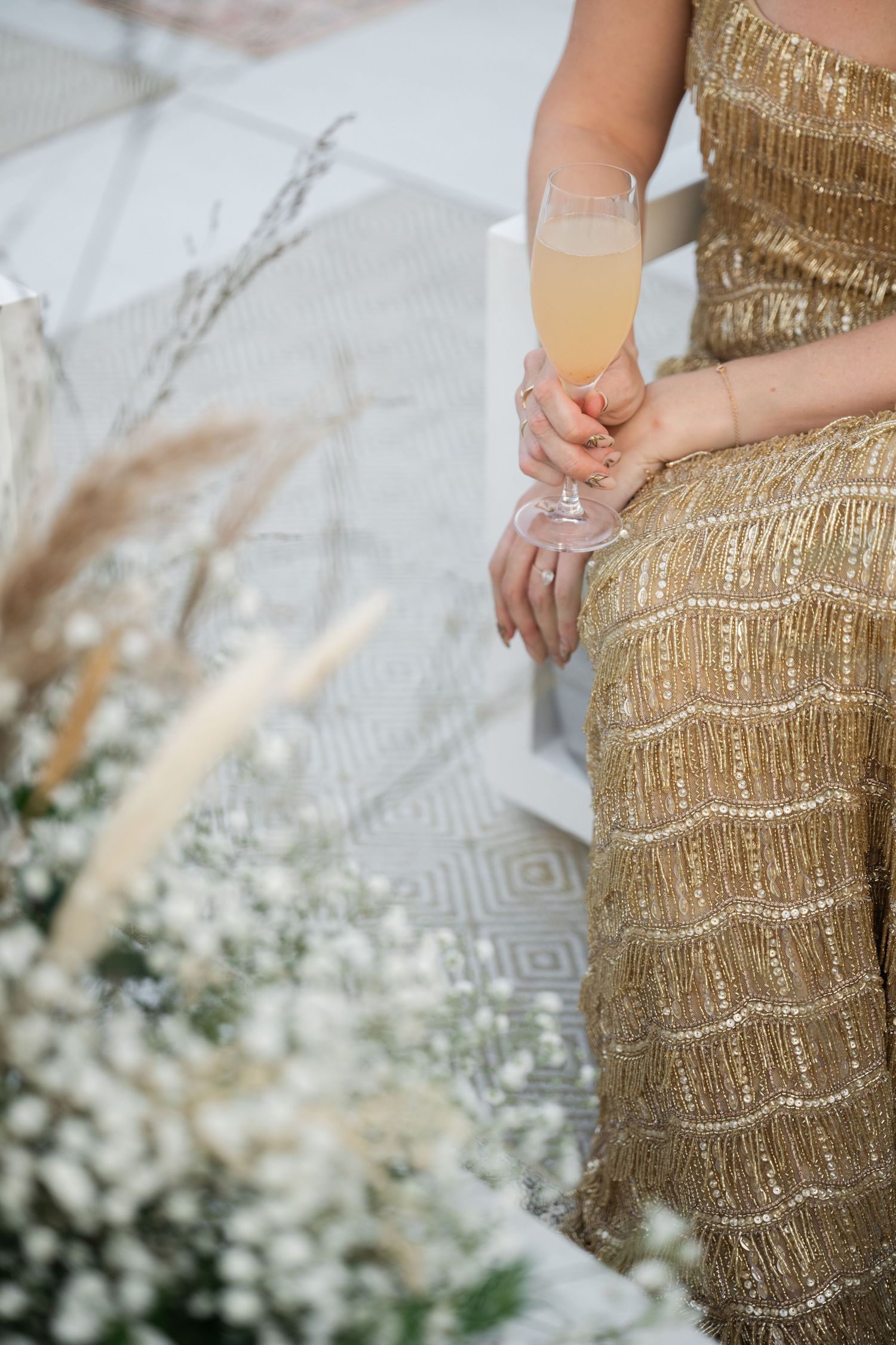 Gold sequined wedding dress detail with intricate beading pattern.